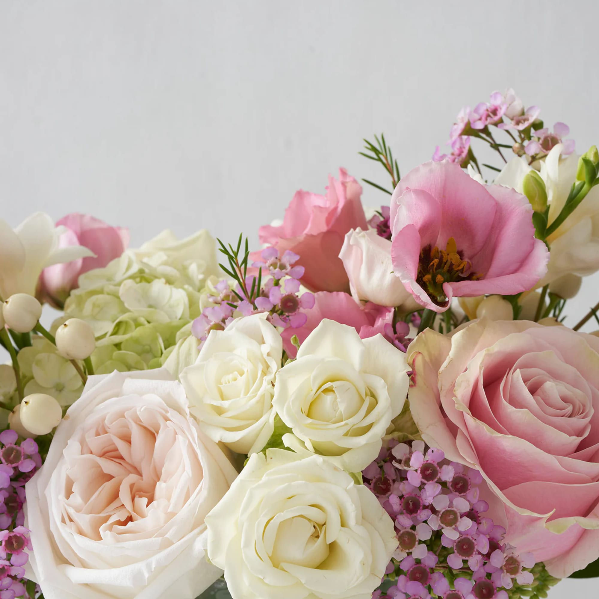 Bouquet of pink and white roses with small purple filler flowers