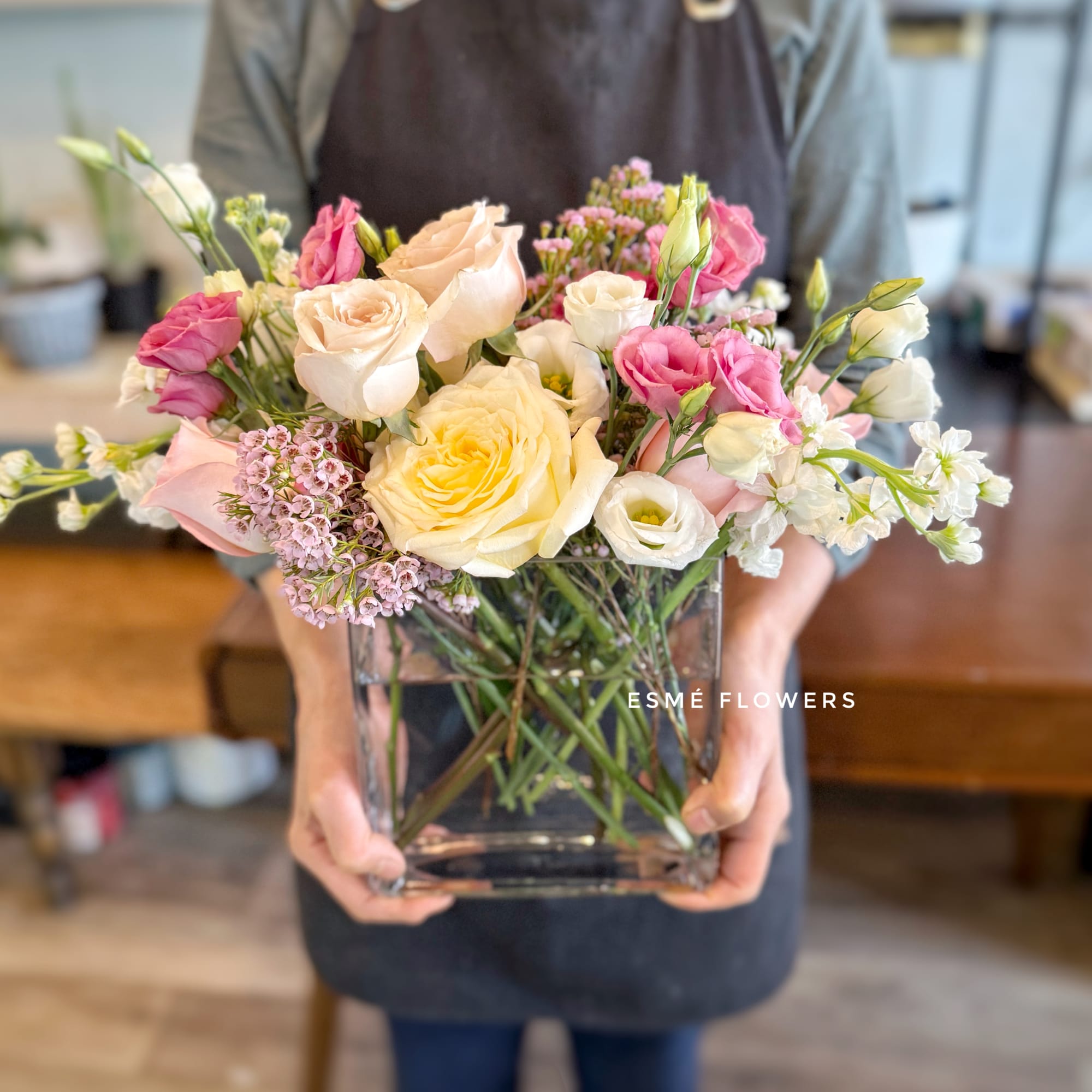 Mixed bouquet of roses and lisianthus in a clear glass vase