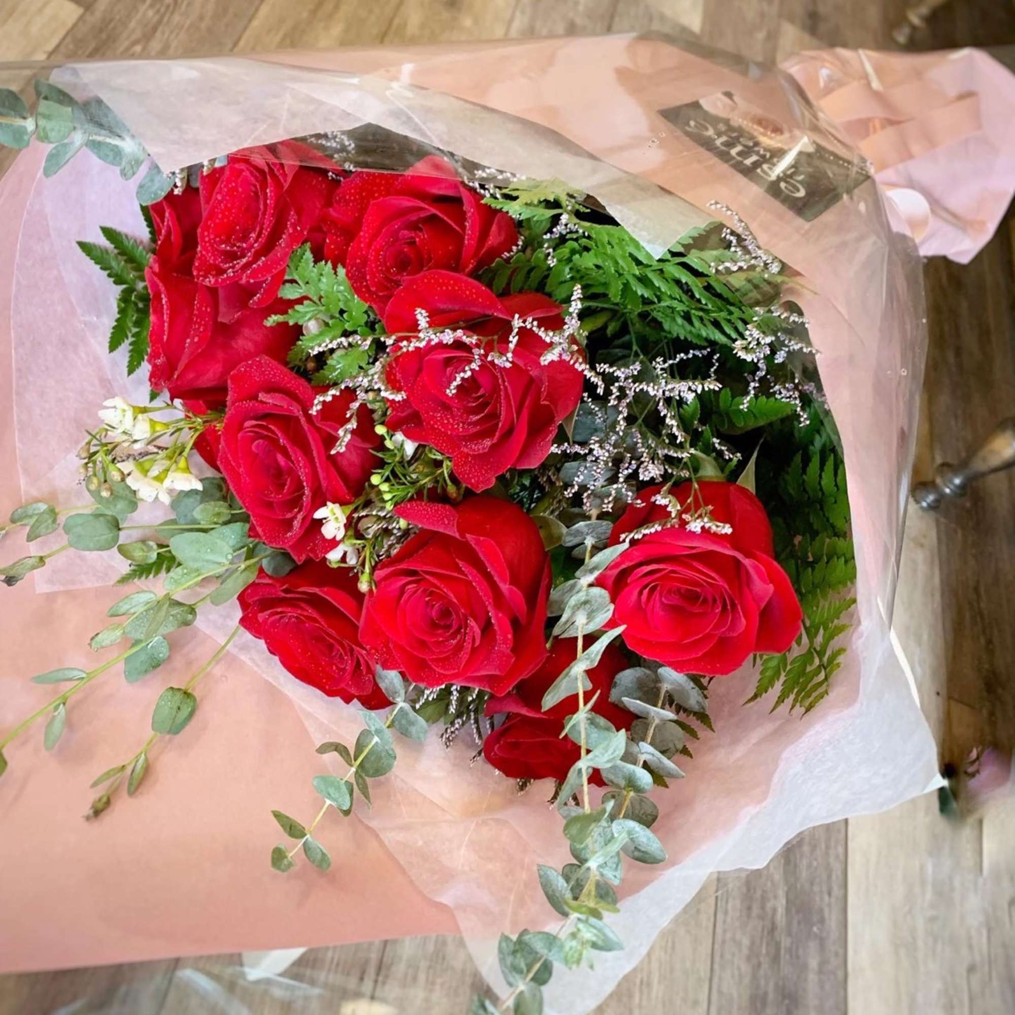Bouquet of red roses wrapped in pink paper