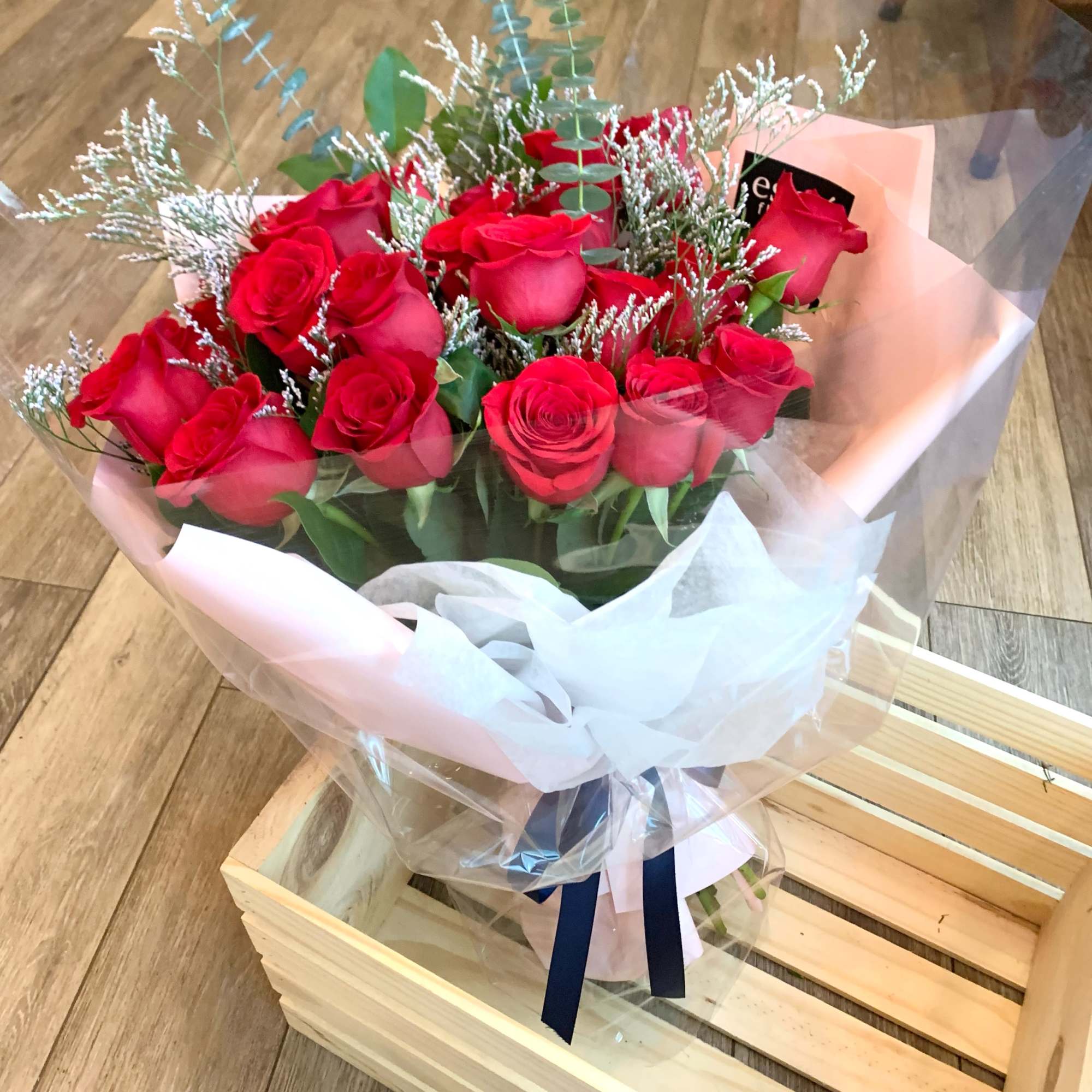 Bouquet of red roses wrapped in pink and clear paper