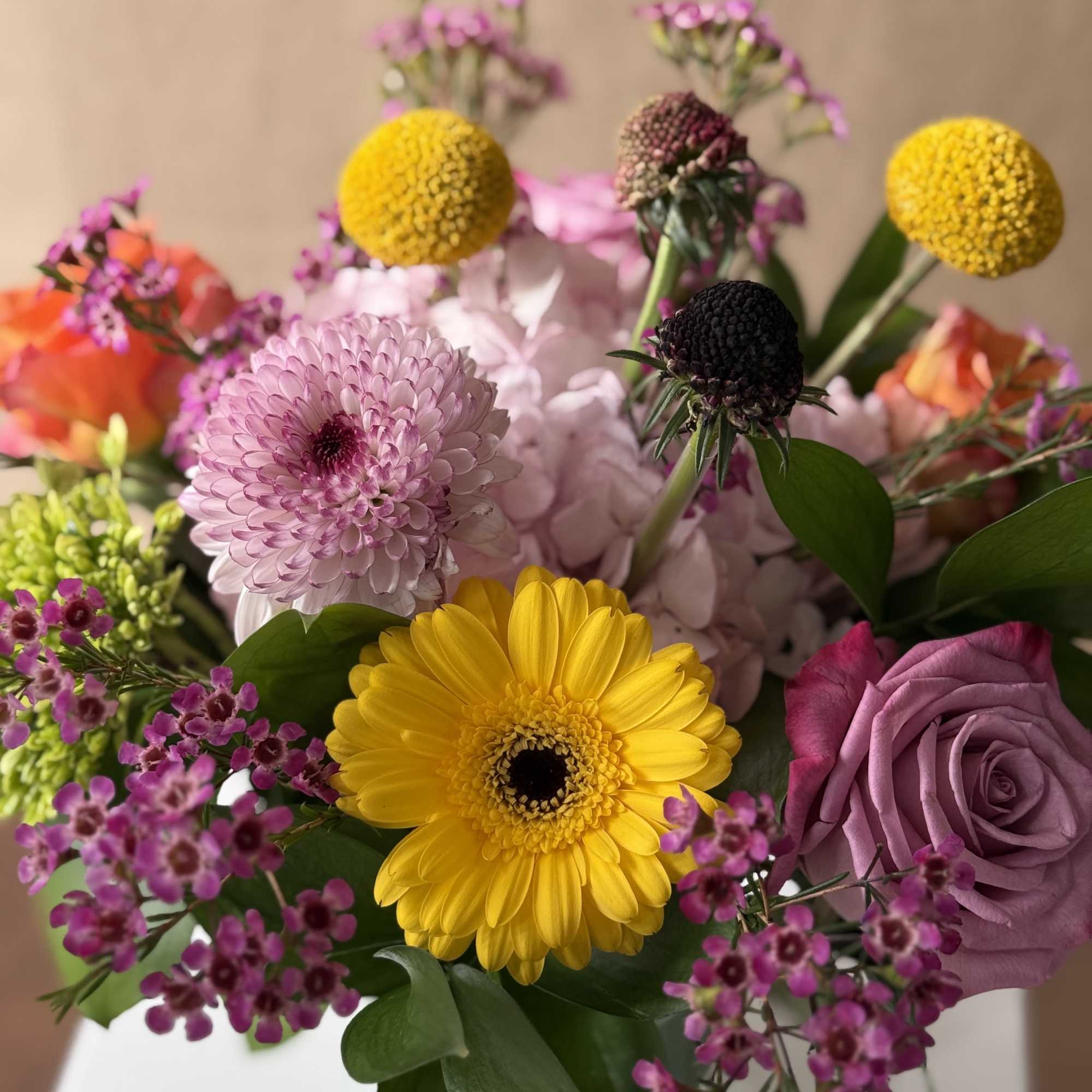 Seasonal and colorful variety of flowers in a clear glass vase. 