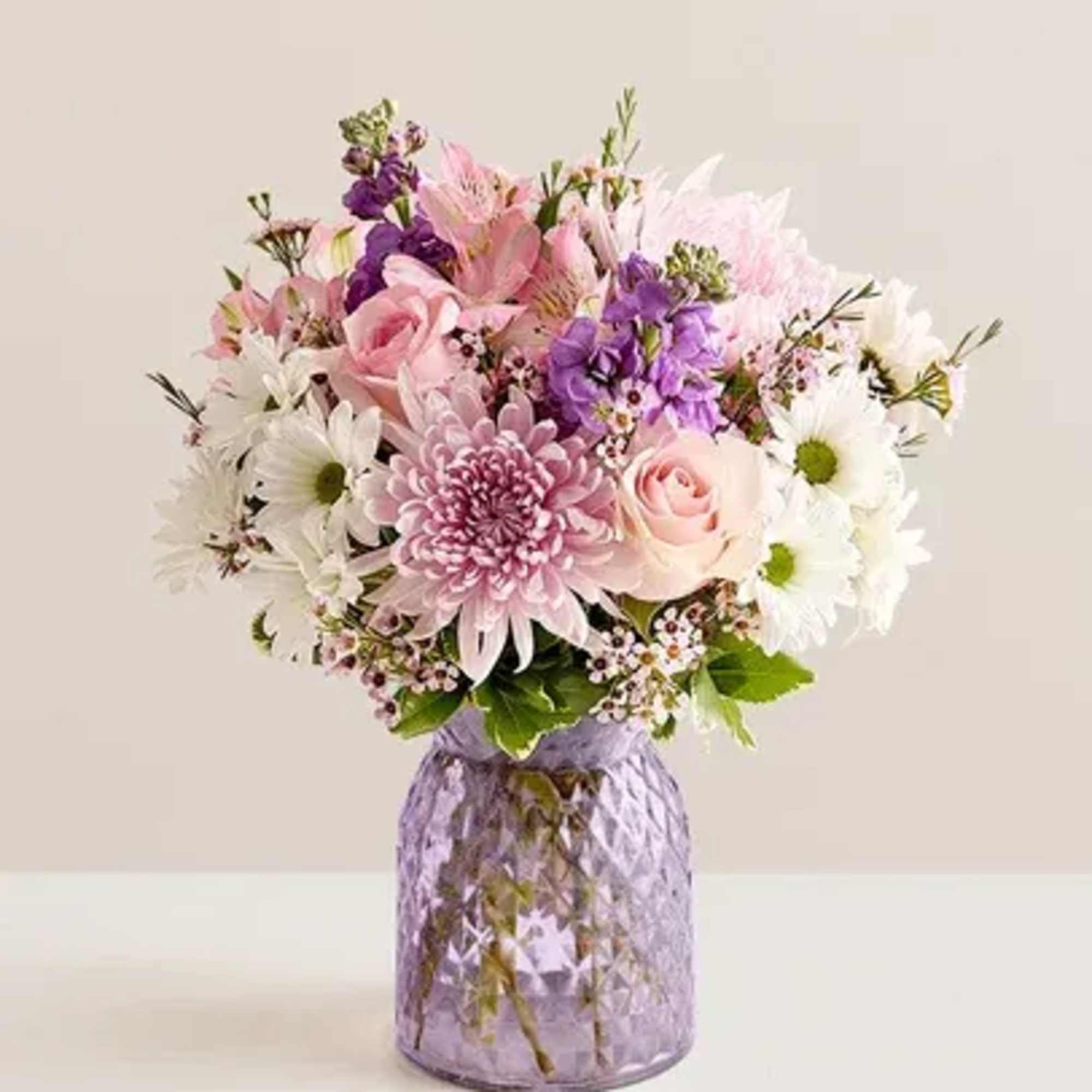 Pink and white mixed bouquet in a purple glass vase