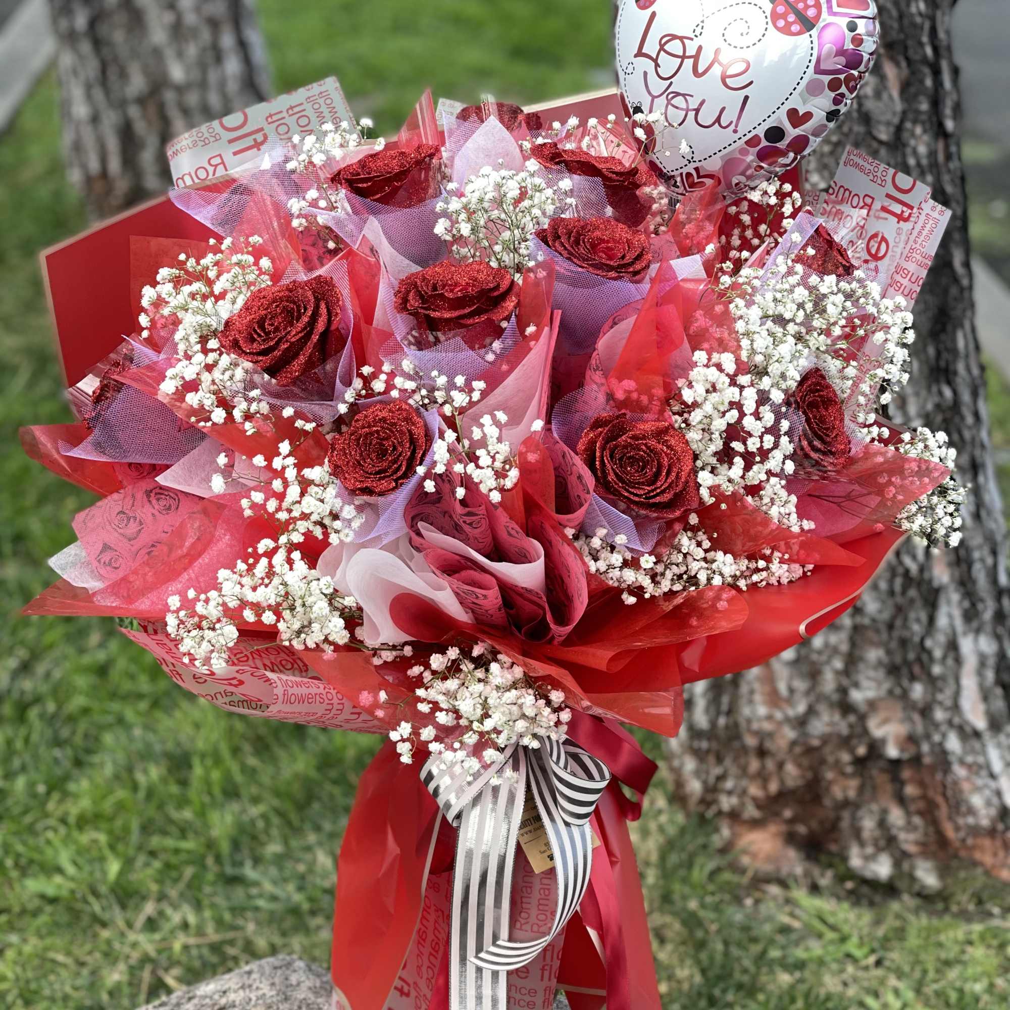 Red rose bouquet with baby's breath and a heart-shaped "Love you!" balloon