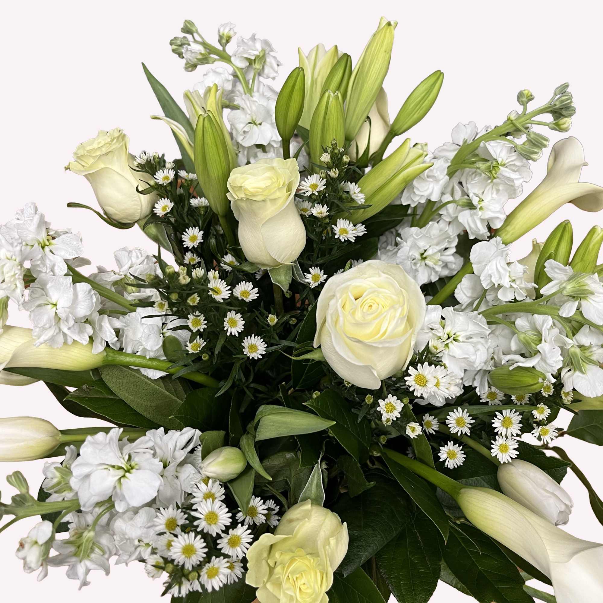 White roses, lilies, calla lilies, and small daisies in a bouquet