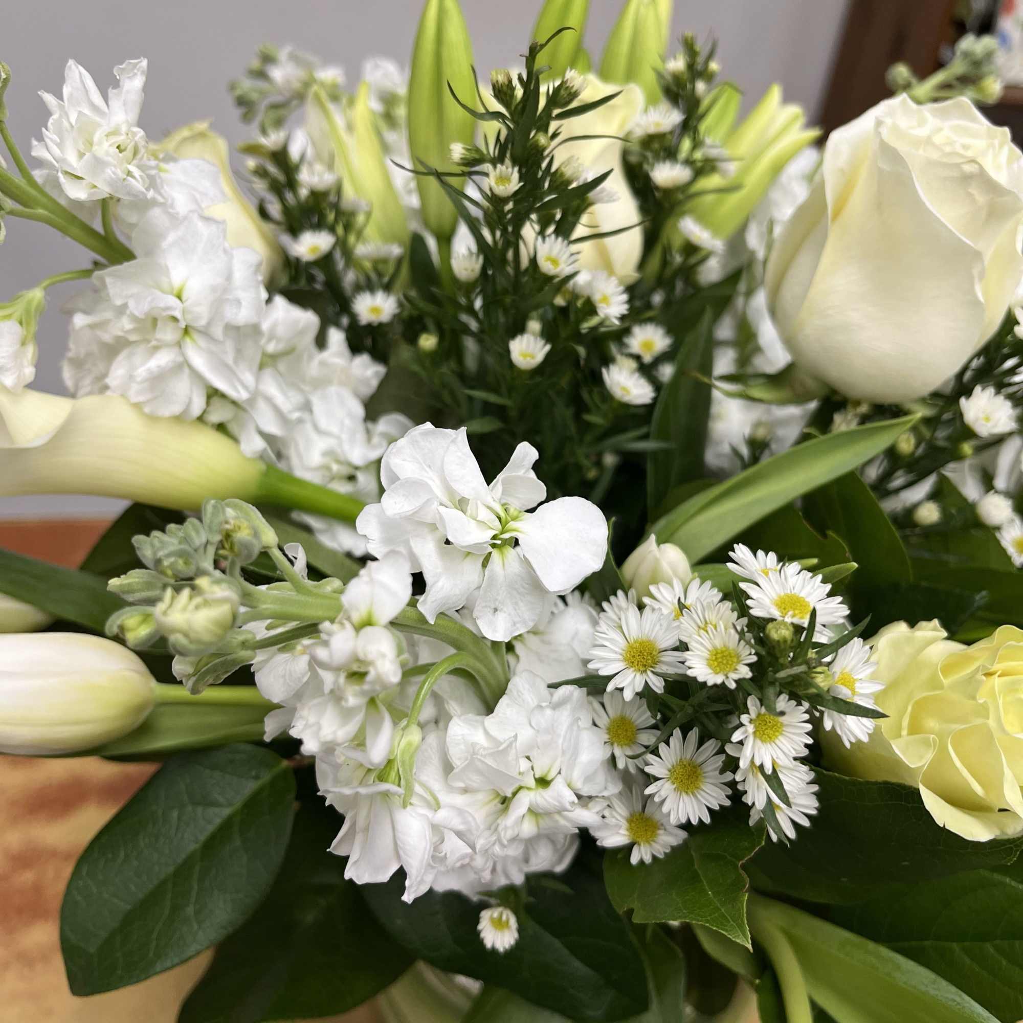 White bouquet with roses, tulips, and small daisy-like flowers