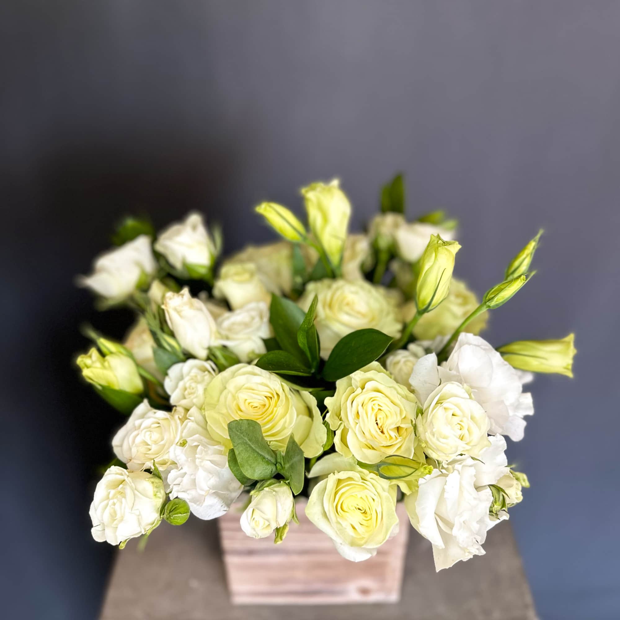 Cream and white roses arranged in a square wooden box