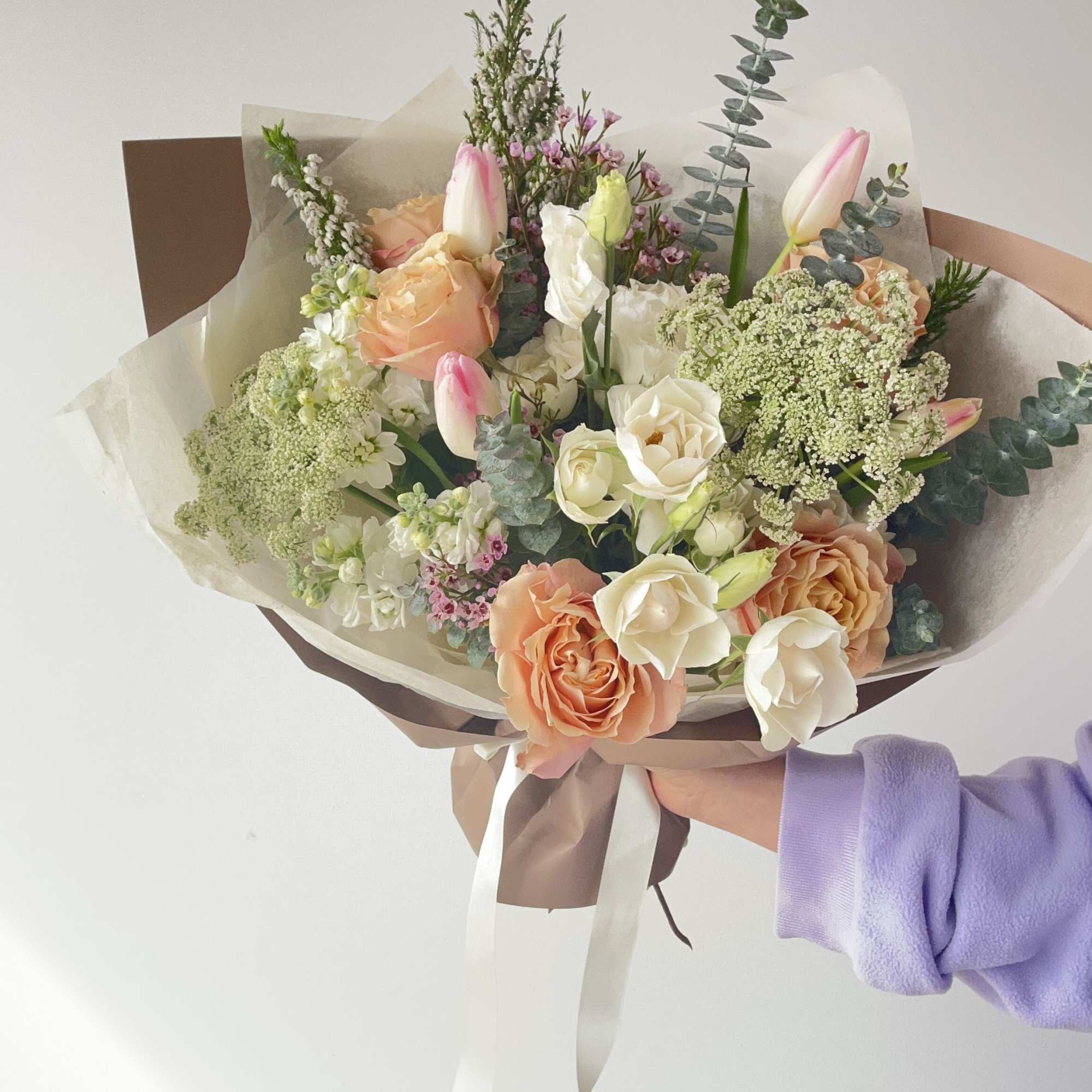 Hand-tied bouquet of peach and white roses with pink tulips