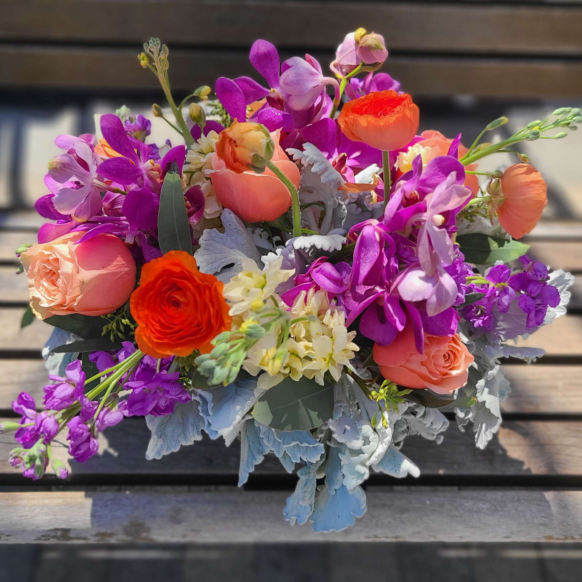 Bouquet of orange and purple flowers with silvery foliage