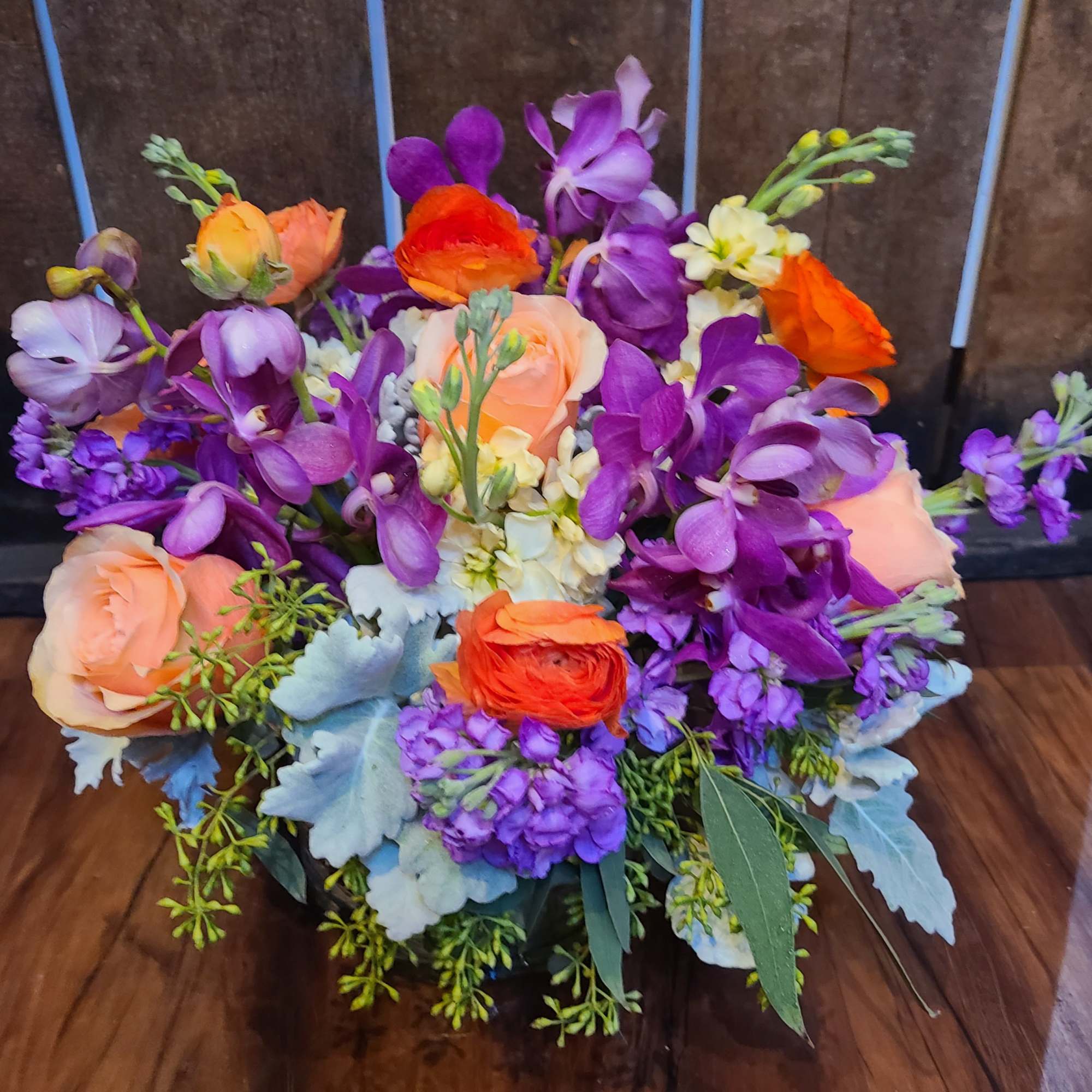 This arrangement is a new design using peaches, oranges and purples. The