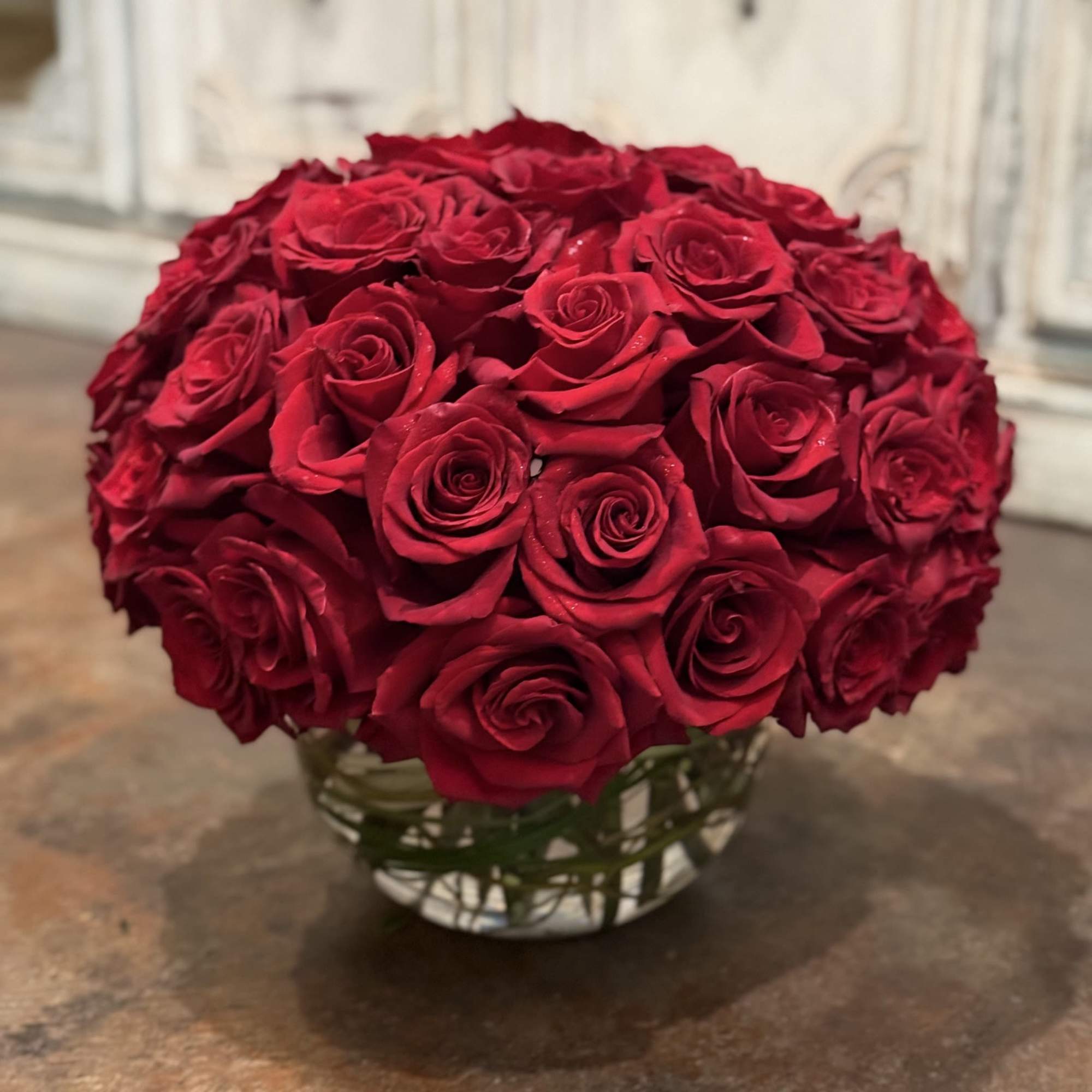 Round bouquet of red roses in a glass vase