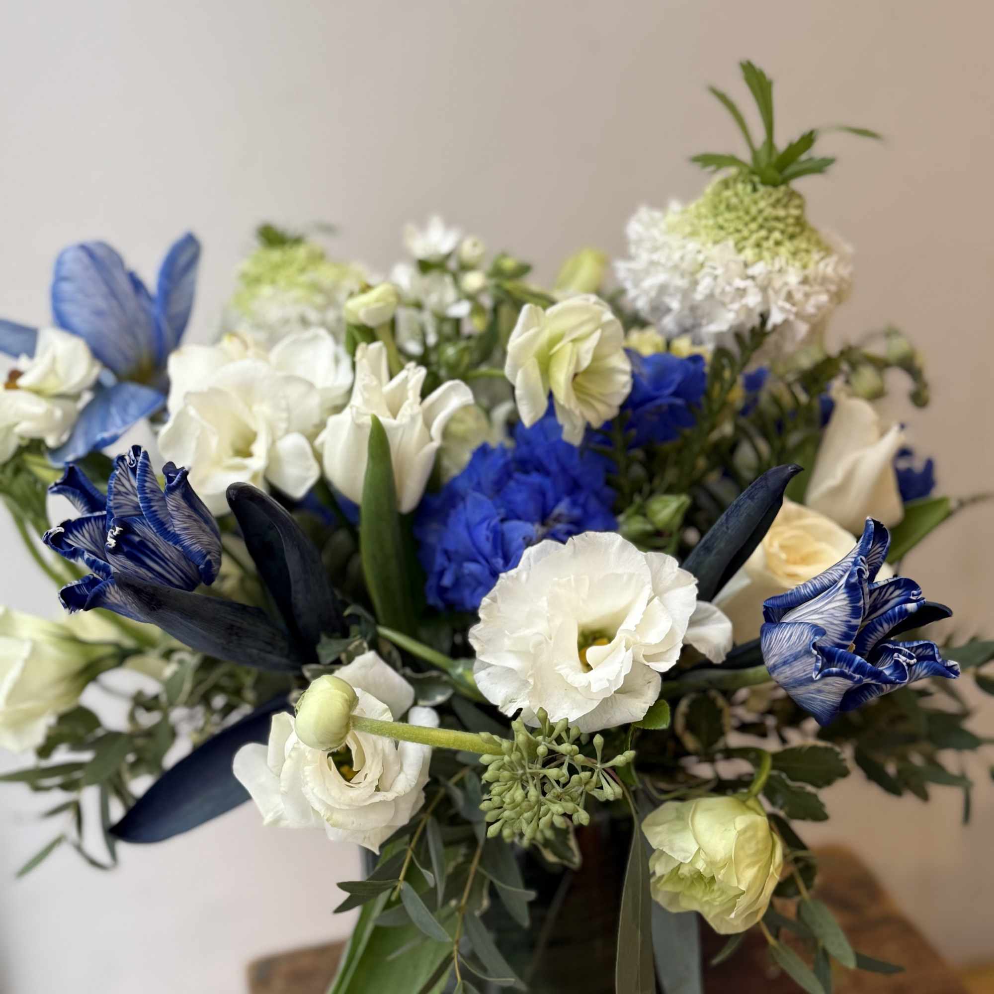 Blue and white floral arrangement in a dark vase