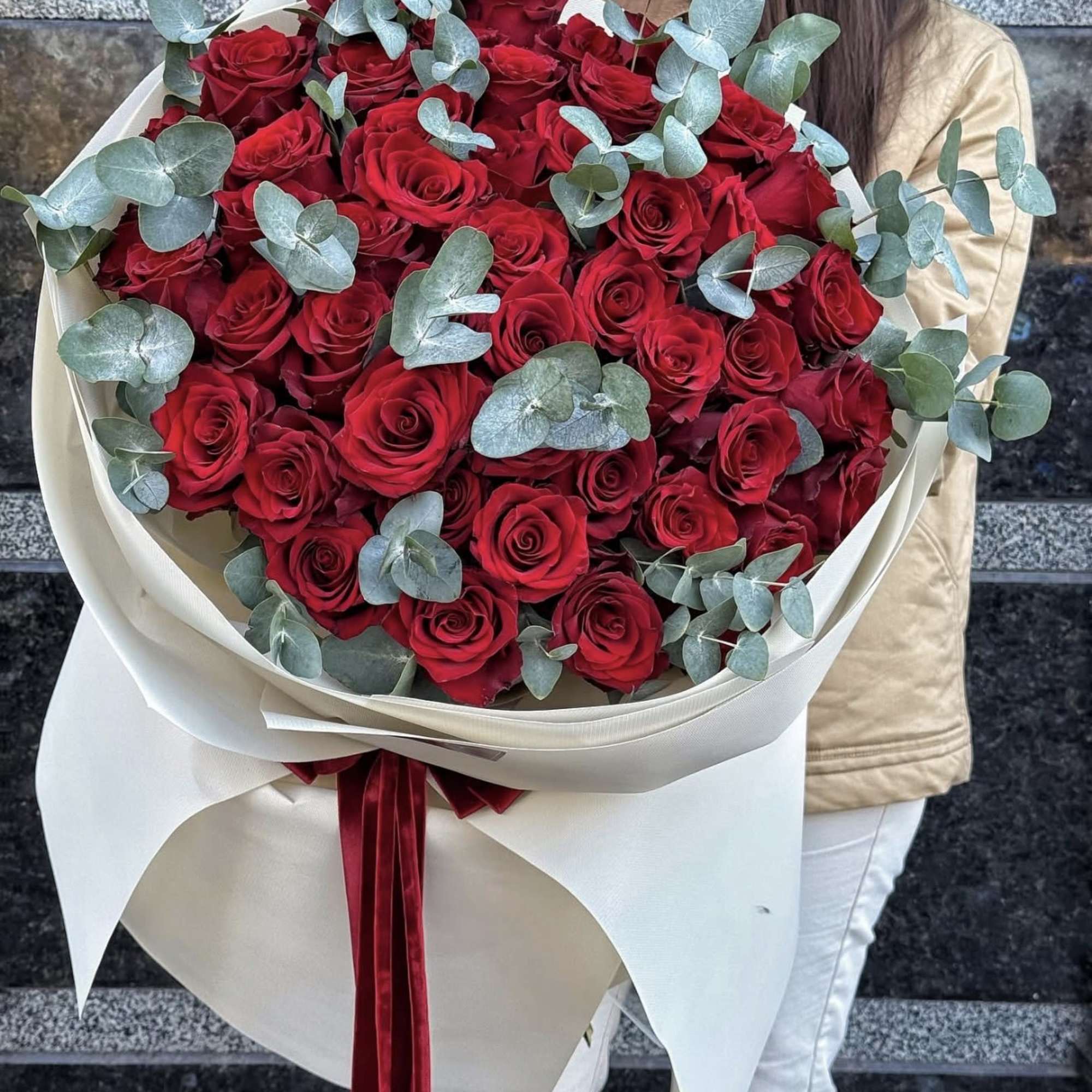 Large bouquet of red roses with eucalyptus and cream wrapping