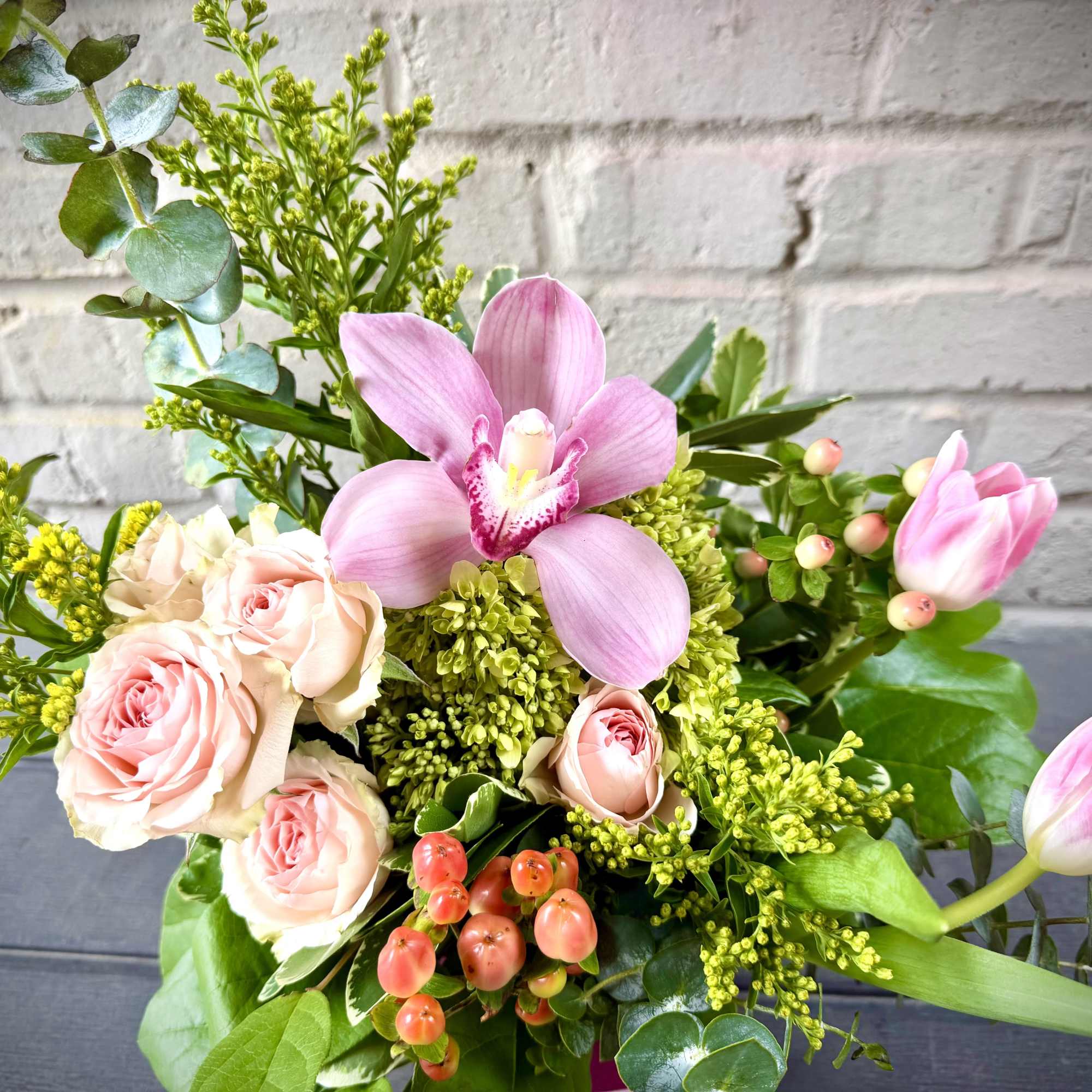 Soft pink orchids and blush roses take center stage in this celebratory