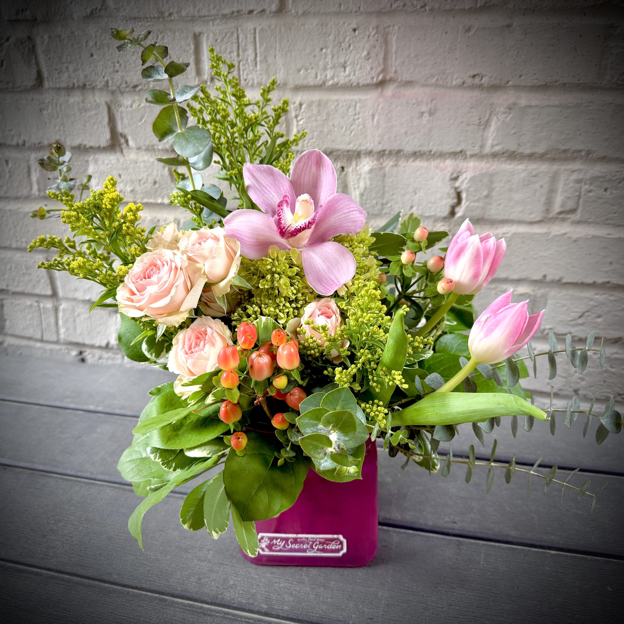 Soft pink orchids and blush roses take center stage in this celebratory