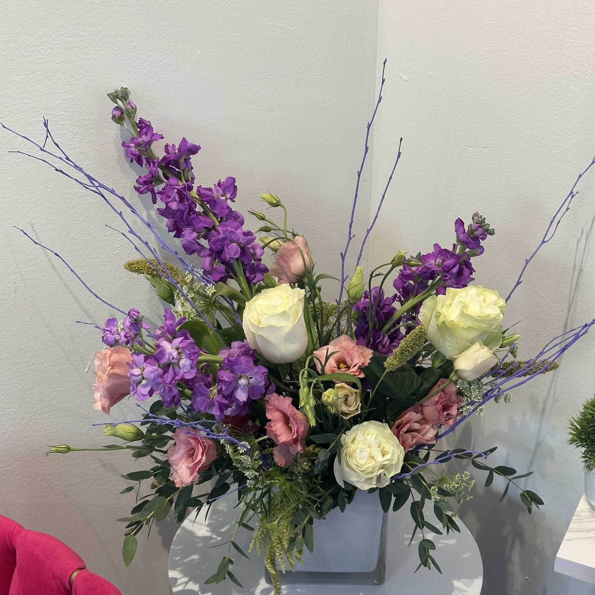 Purple and pink floral arrangement in a square vase