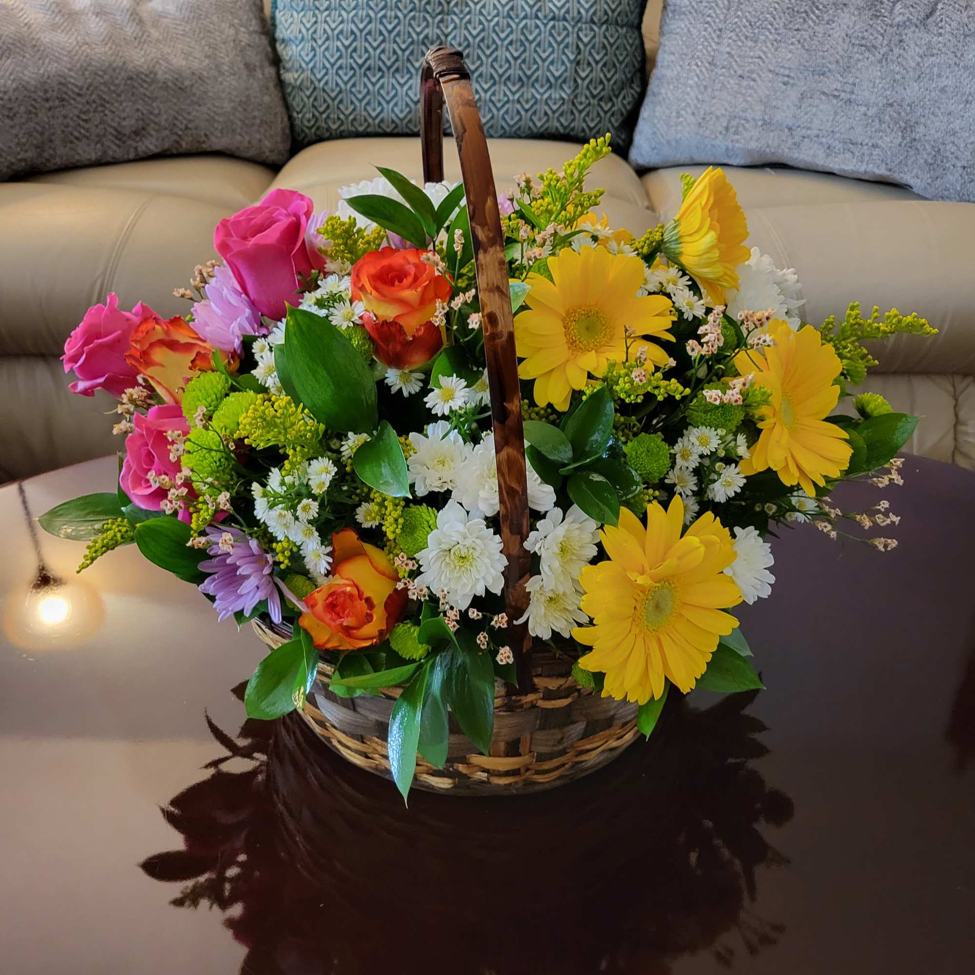 Basket arrangement of colorful roses, daisies, and chrysanthemums