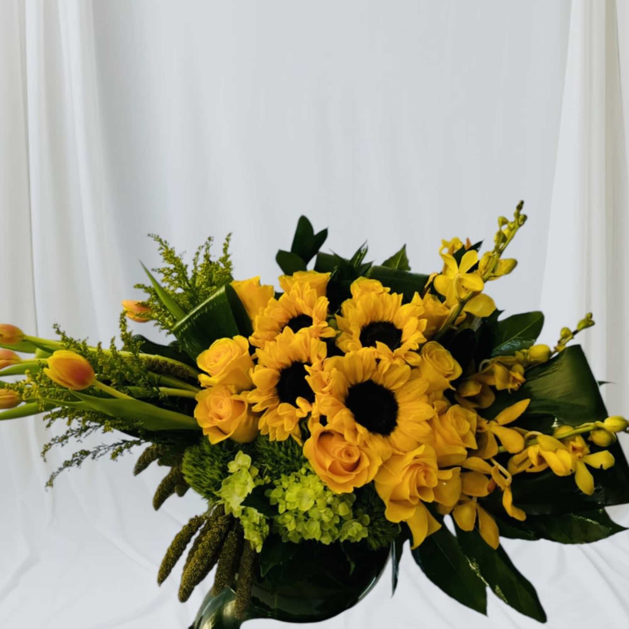 Yellow sunflower and rose bouquet with orchids in a vase