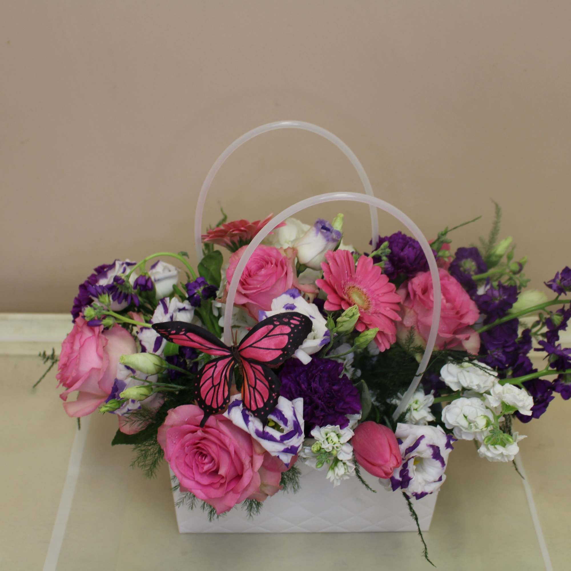 A bright decorative like pocketbook full of flowers, this floral arrangement is