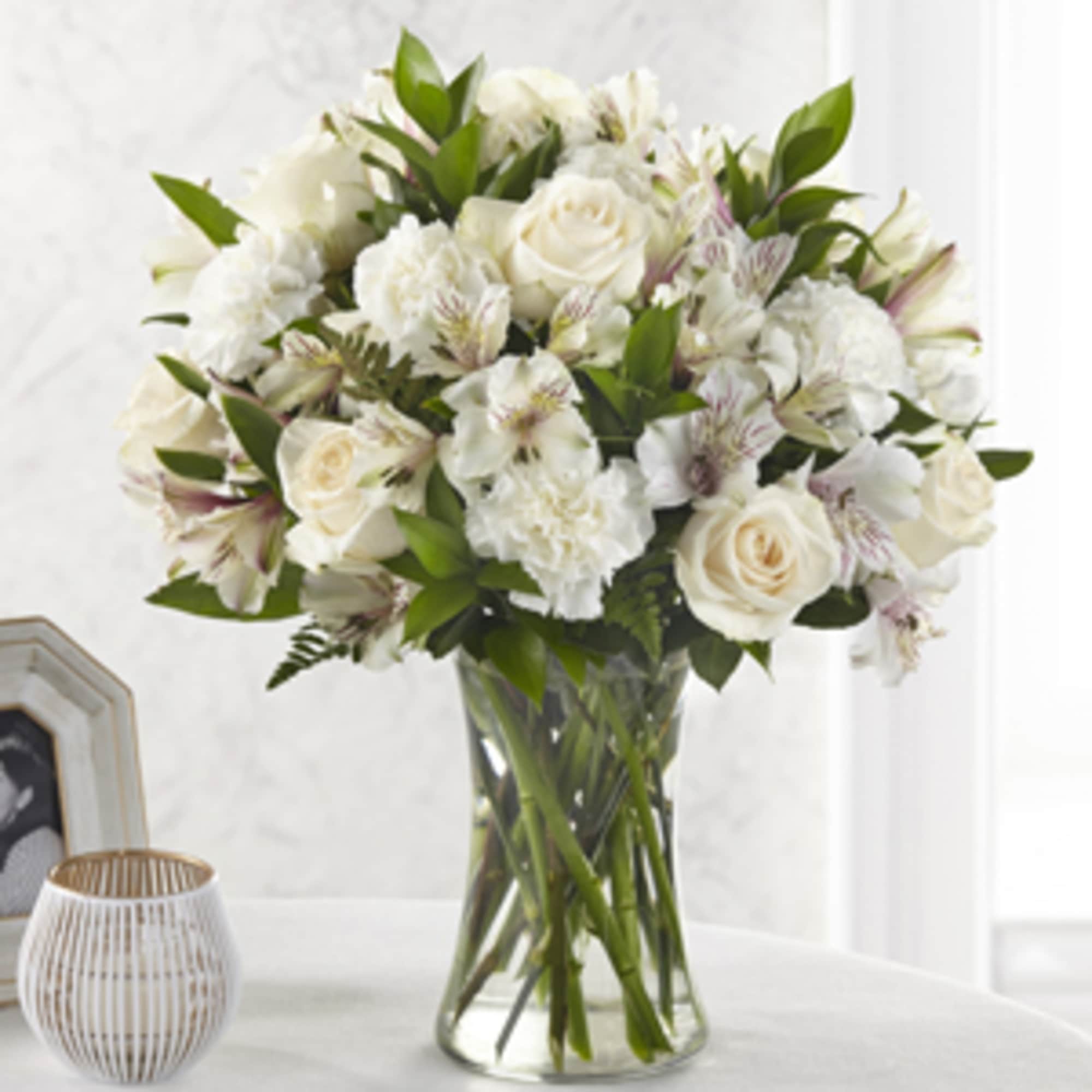 White roses and carnations in a clear glass vase