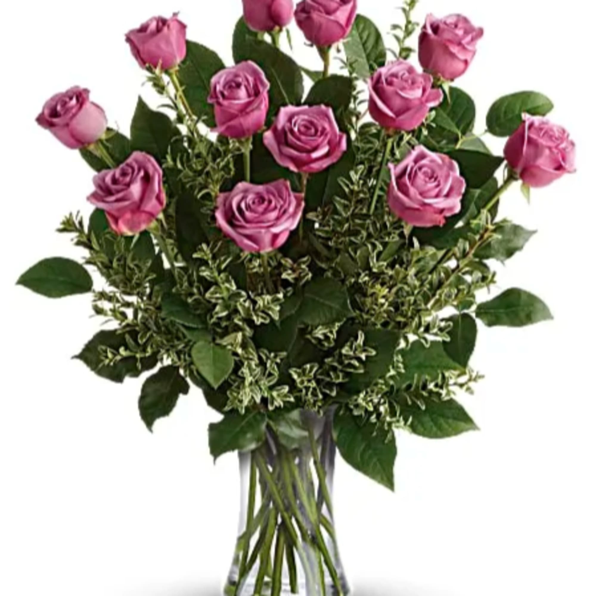 Dozen lavender roses in a clear glass vase with abundant filler foliage