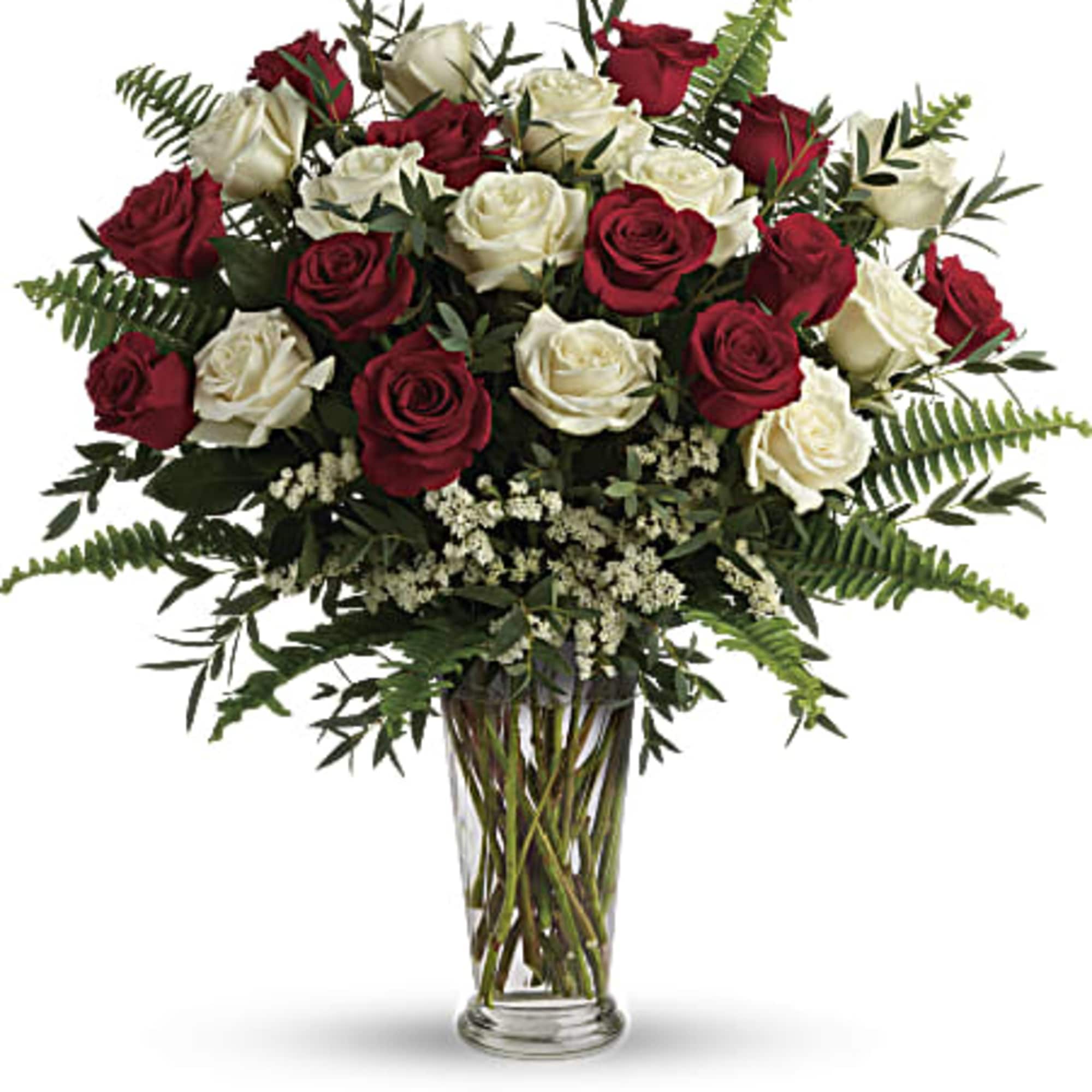 Tall arrangement of red and white roses with ferns in a clear glass vase