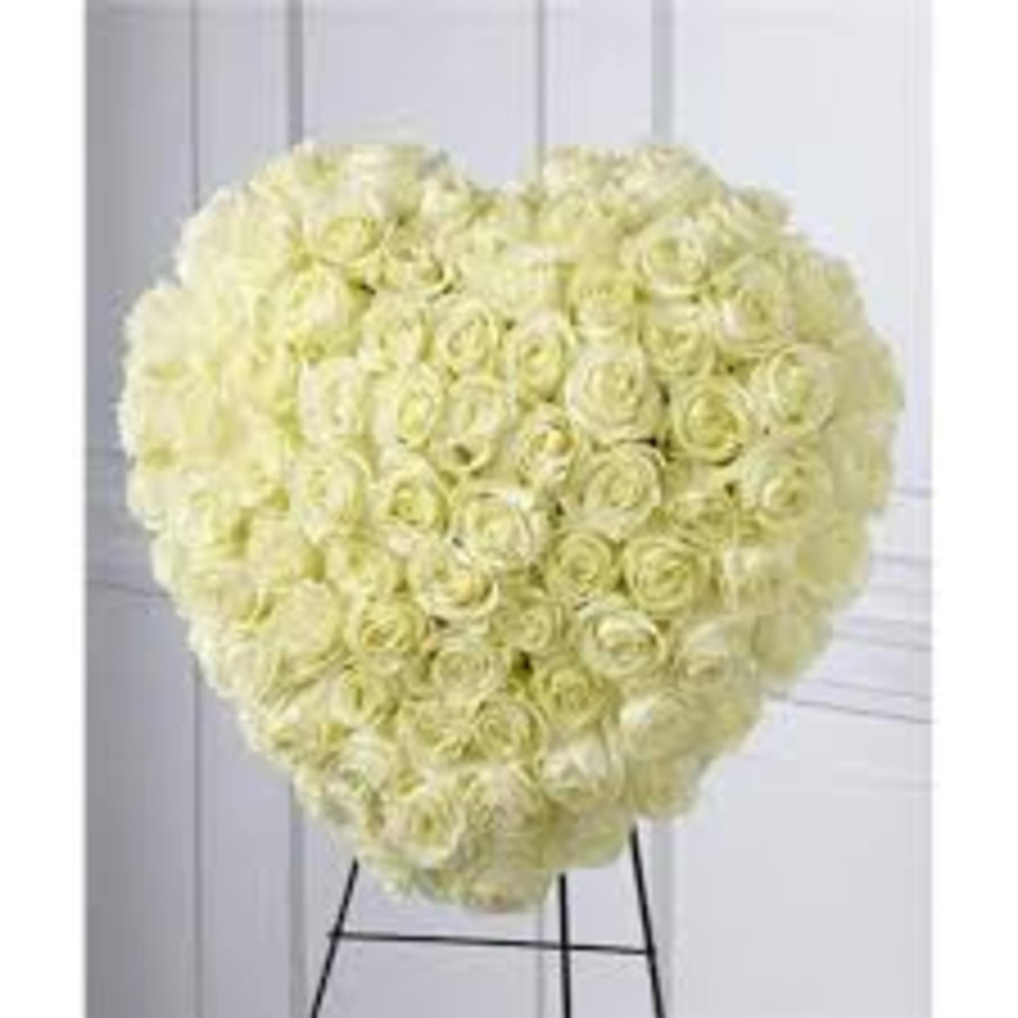 Heart-shaped arrangement of ivory roses on a metal easel