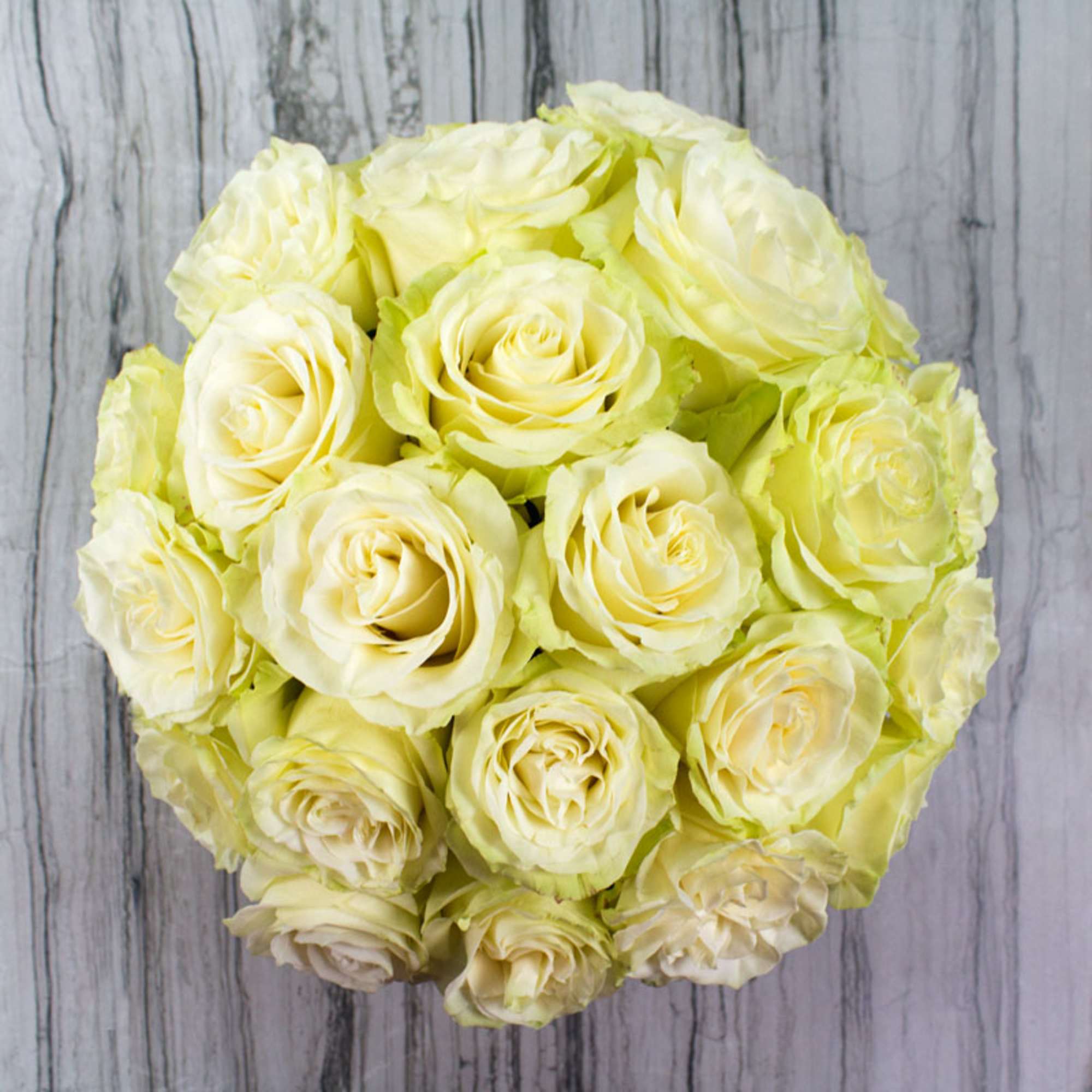 Bouquet of pale yellow roses on a gray wood background