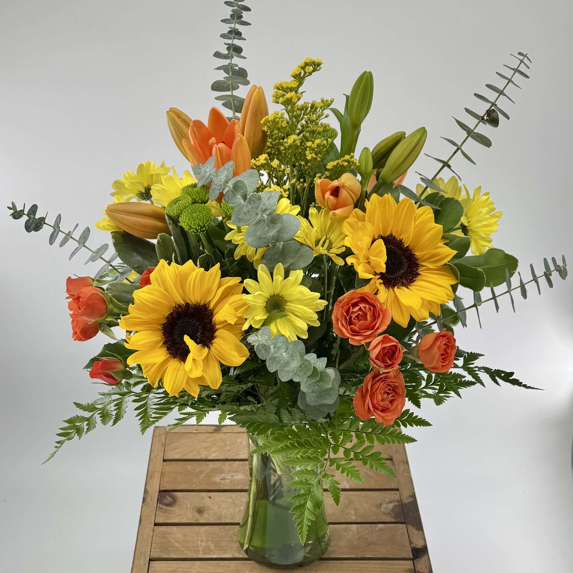 Embrace fall&rsquo;s beauty with this stunning arrangement of orange lilies, spray roses