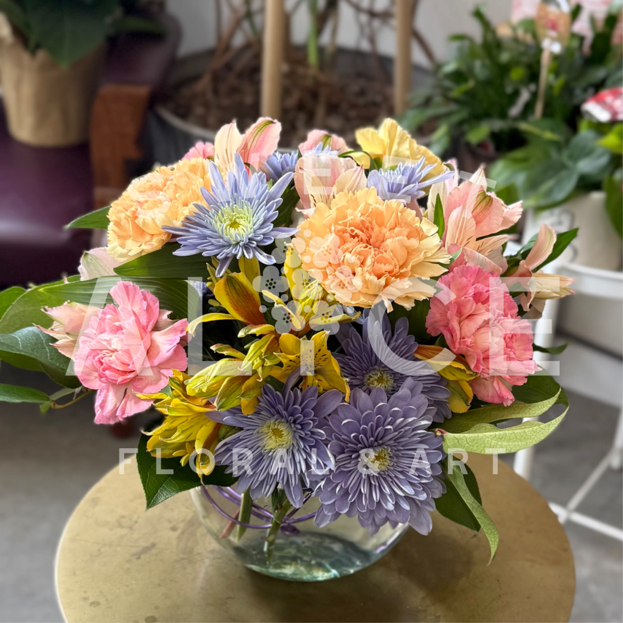 A mixture of our favorite bright flowers, in a lovely glass bubble