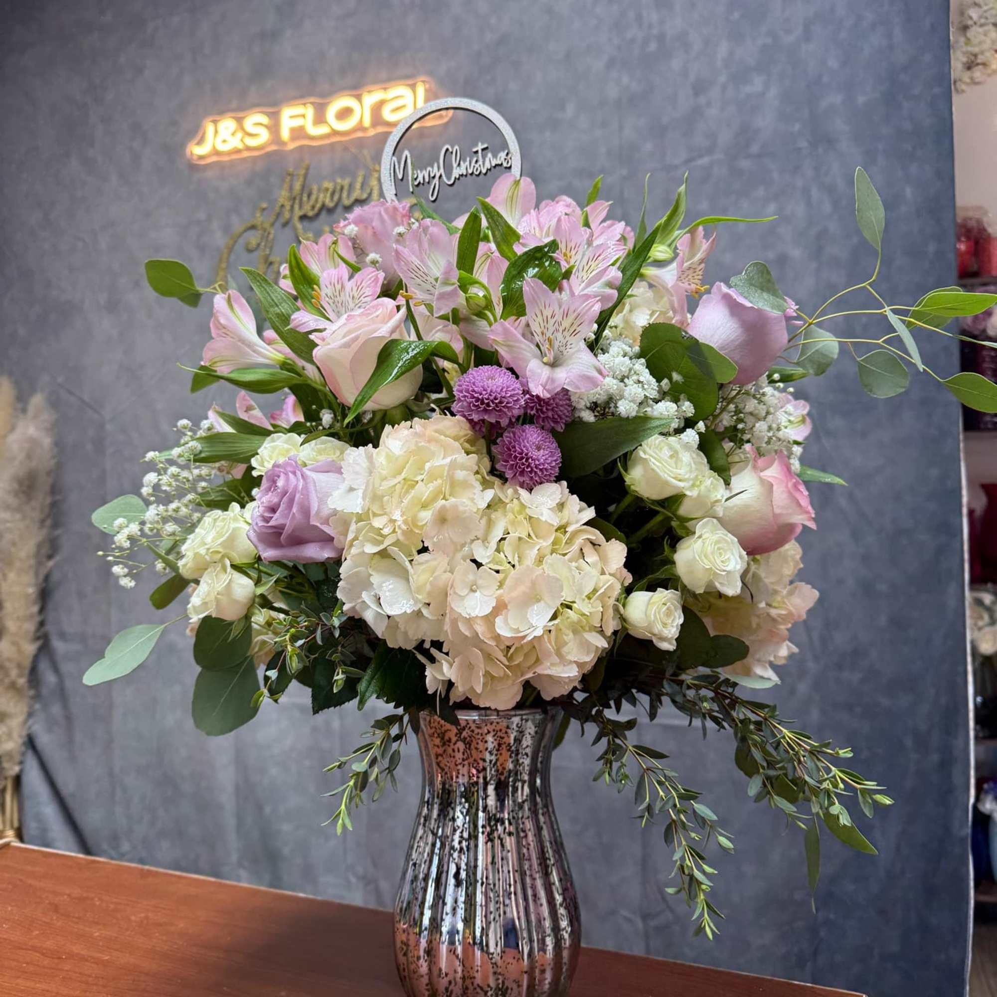 Pastel floral arrangement in a glass vase with pink and cream blooms