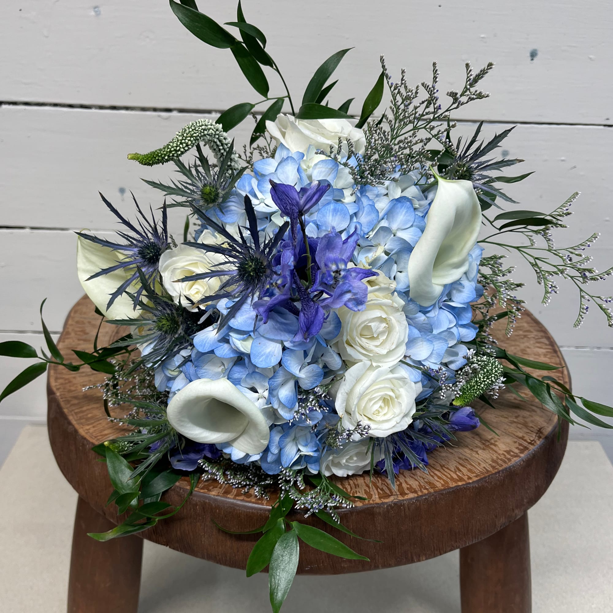 Blue and white bouquet with roses, hydrangea, calla lilies, and iris