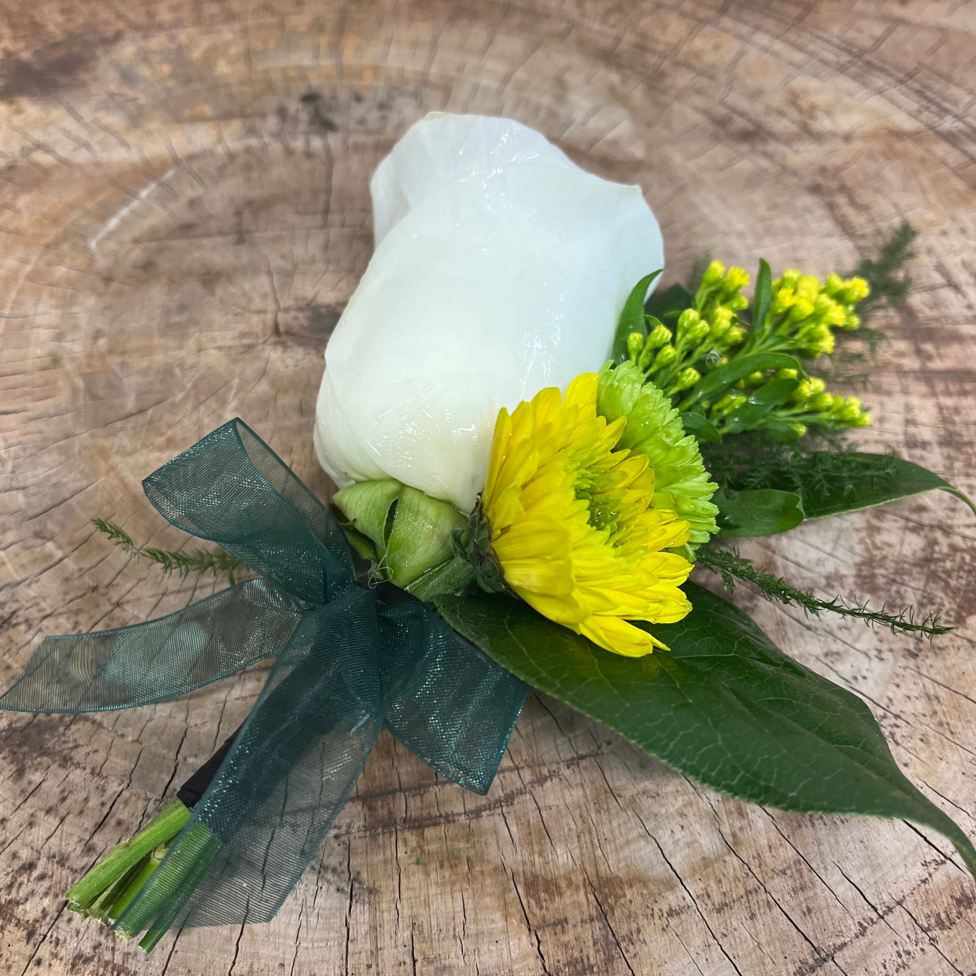 White rose boutonniere with yellow chrysanthemum and green ribbon