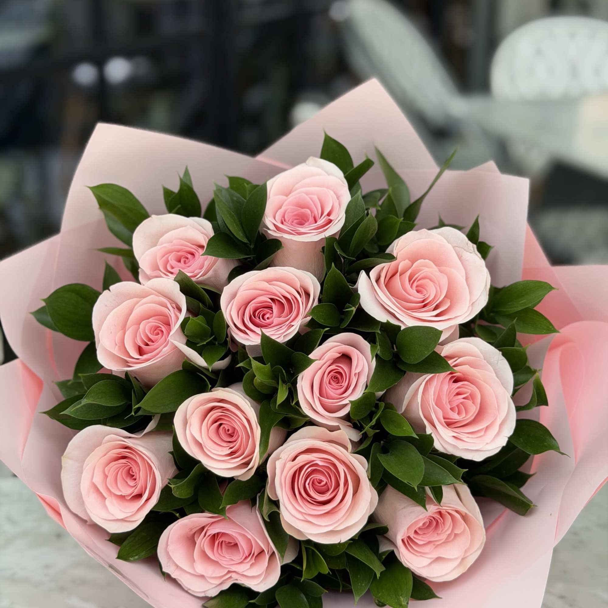 A romantic and elegant arrangement featuring a dozen soft pink roses paired