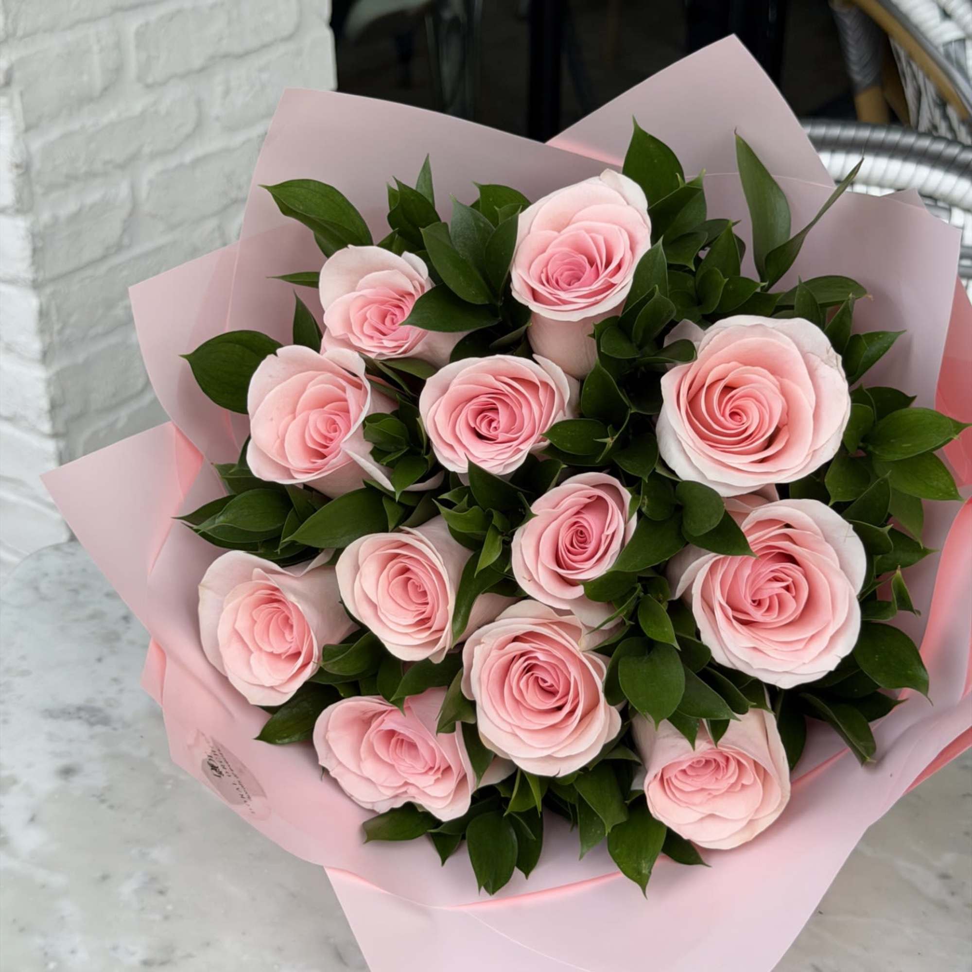 A romantic and elegant arrangement featuring a dozen soft pink roses paired