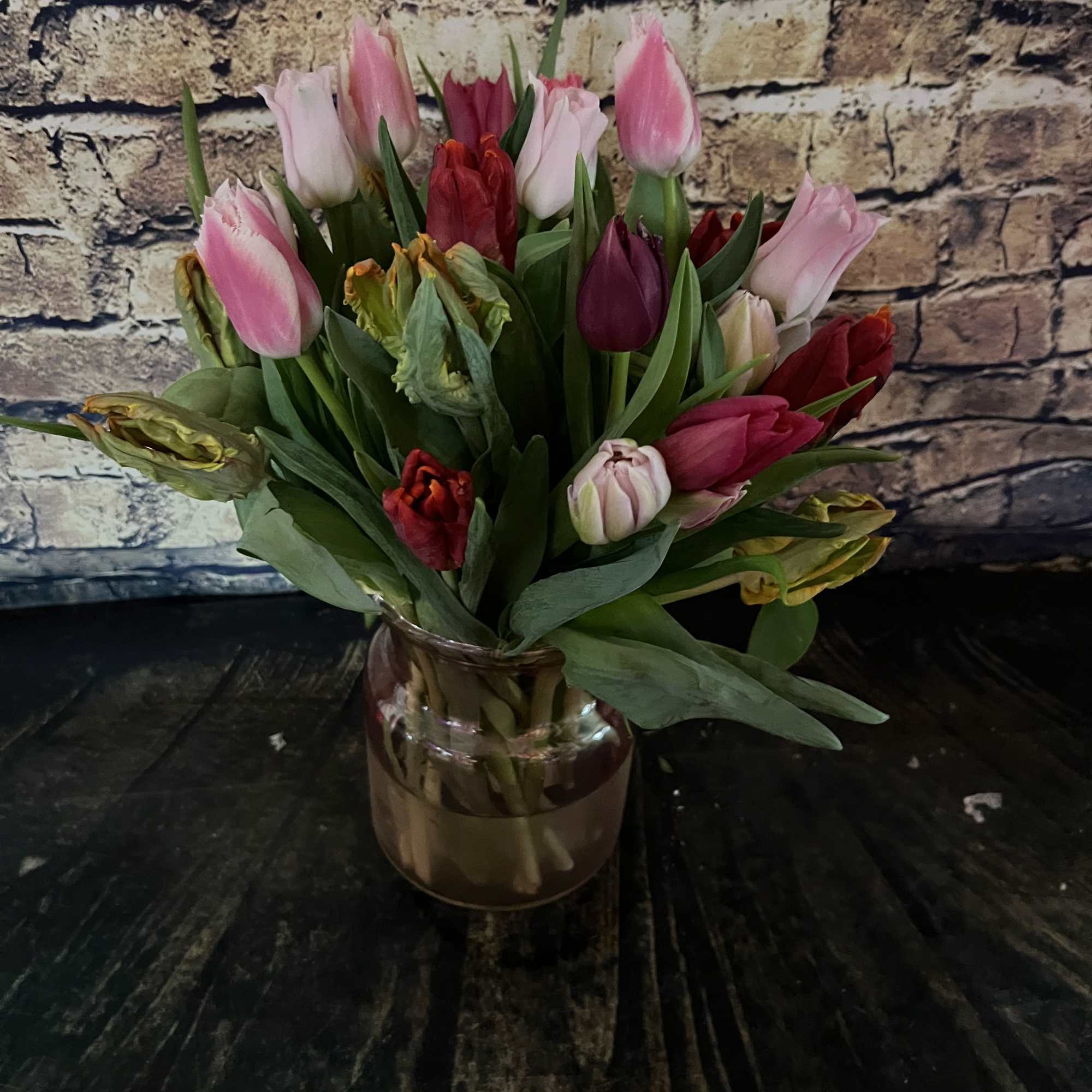 Mixed pink and red tulips arranged in a glass vase