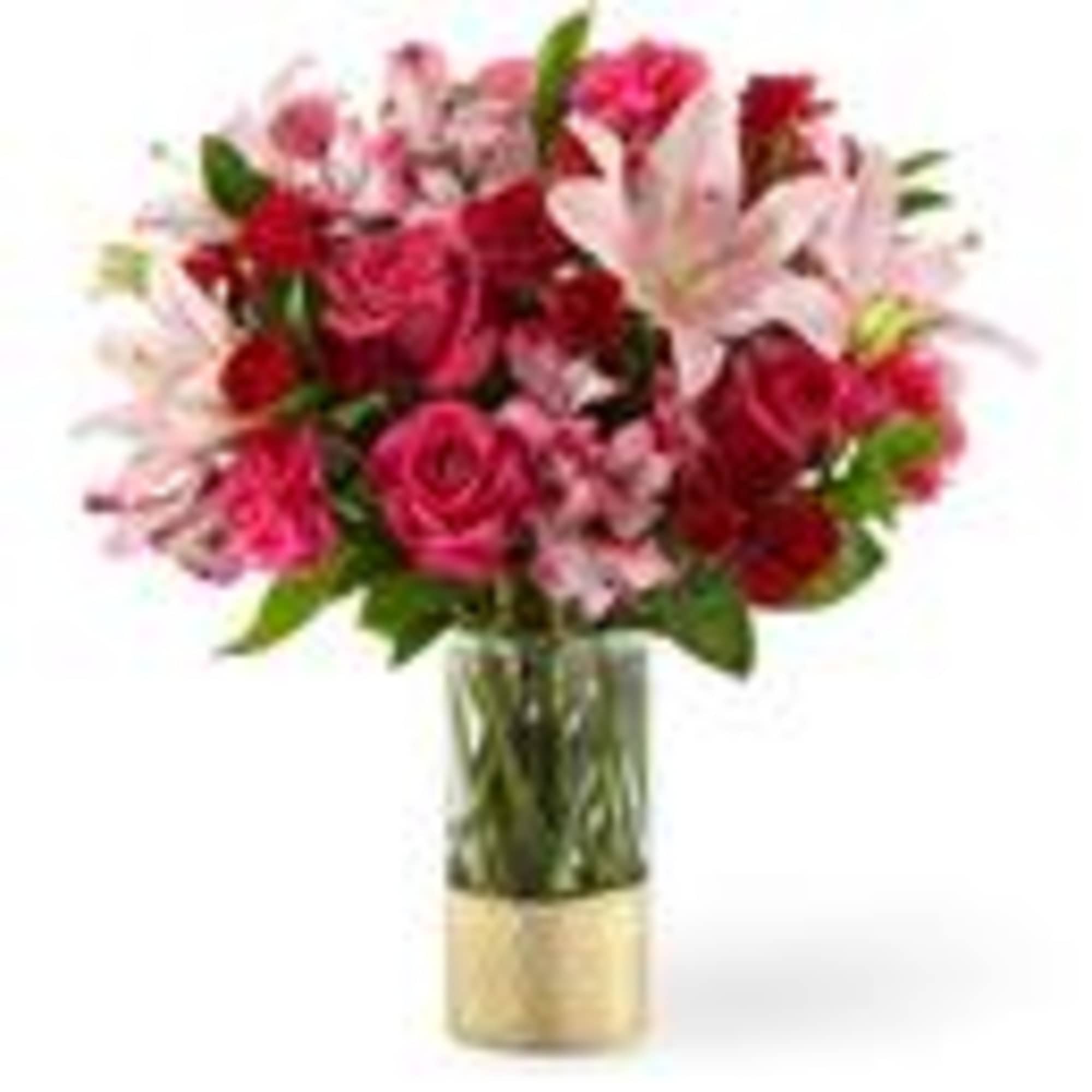 Pink and red mixed bouquet in a glass vase with a gold base