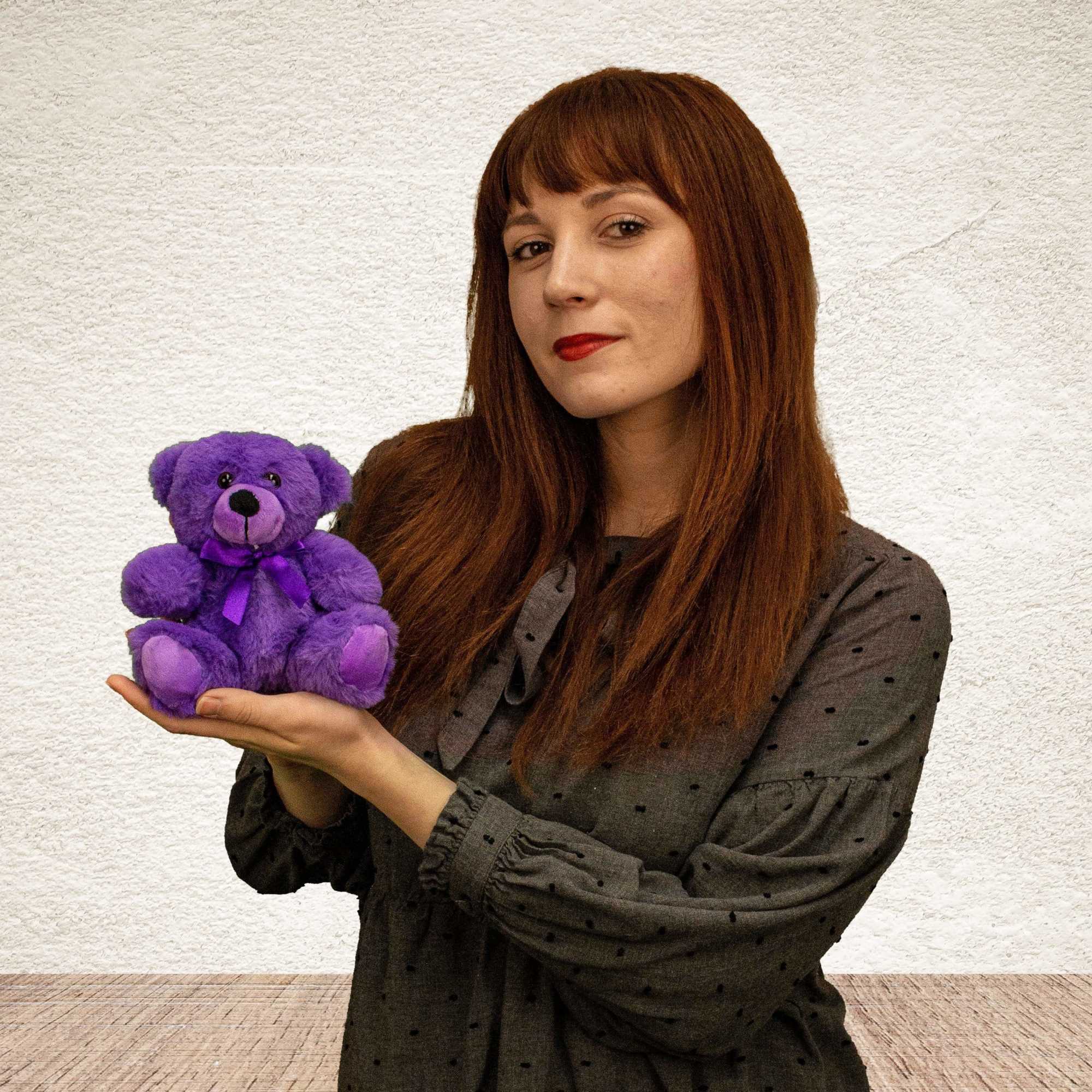 Woman holding a small purple teddy bear