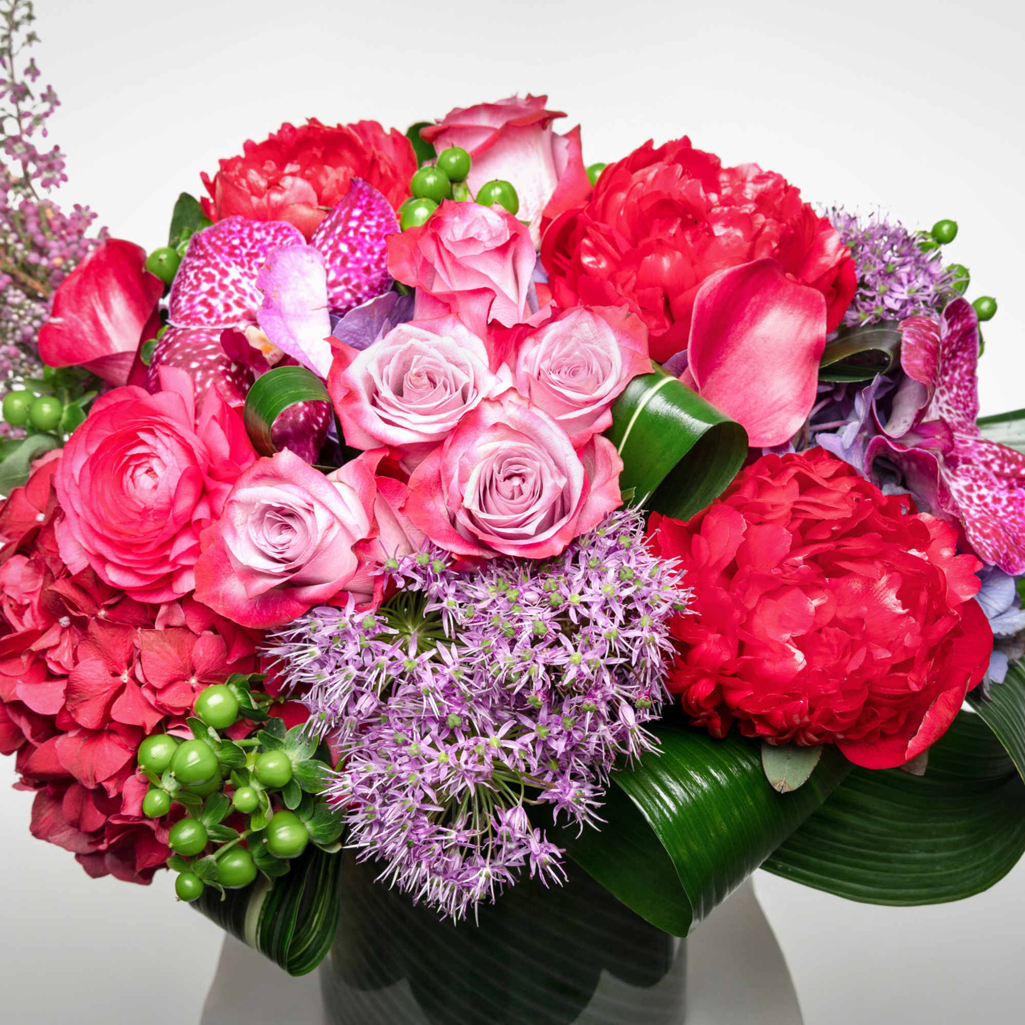 Pink and red mixed bouquet with roses, hydrangeas, and purple accents