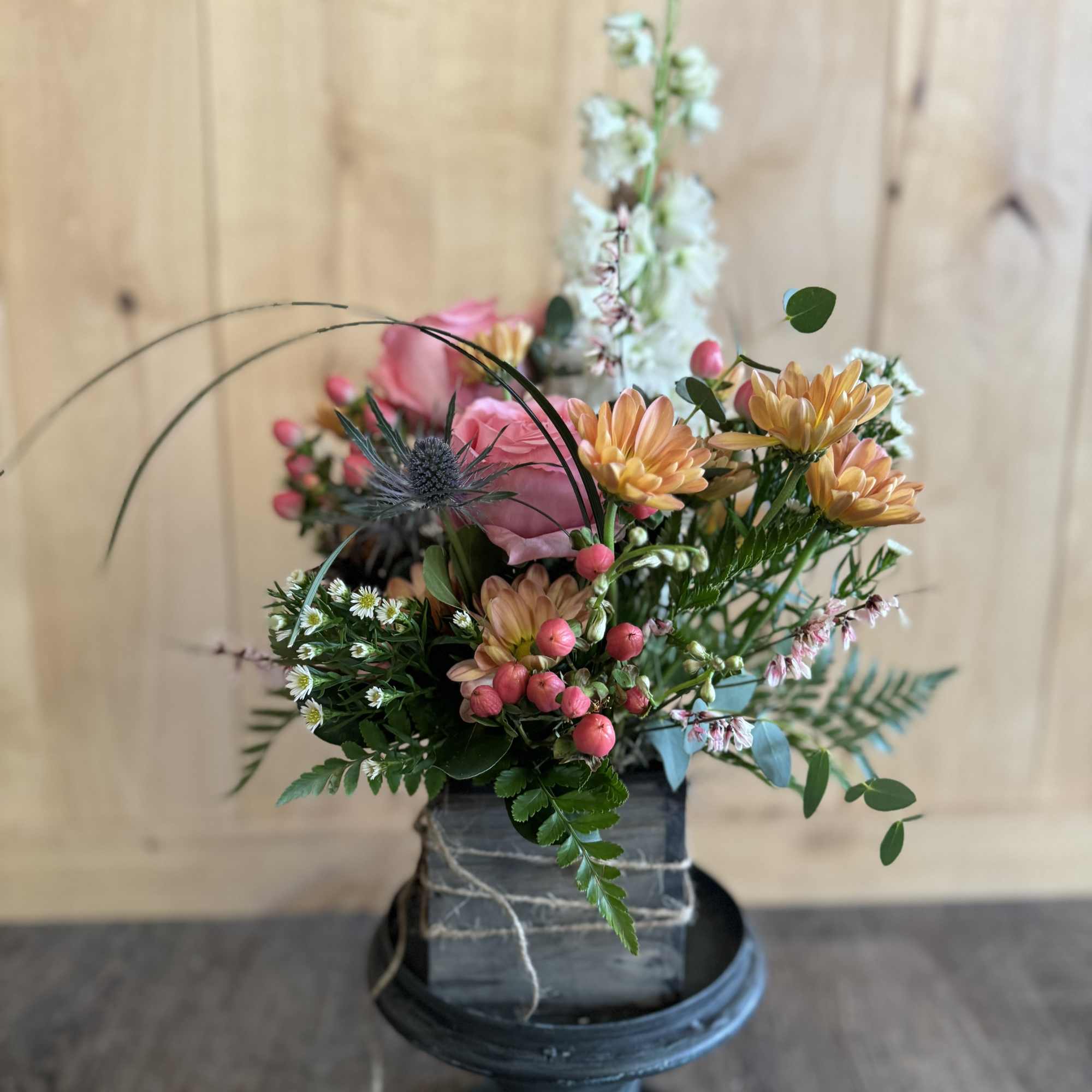 Mixed bouquet in a square container with pink and peach flowers
