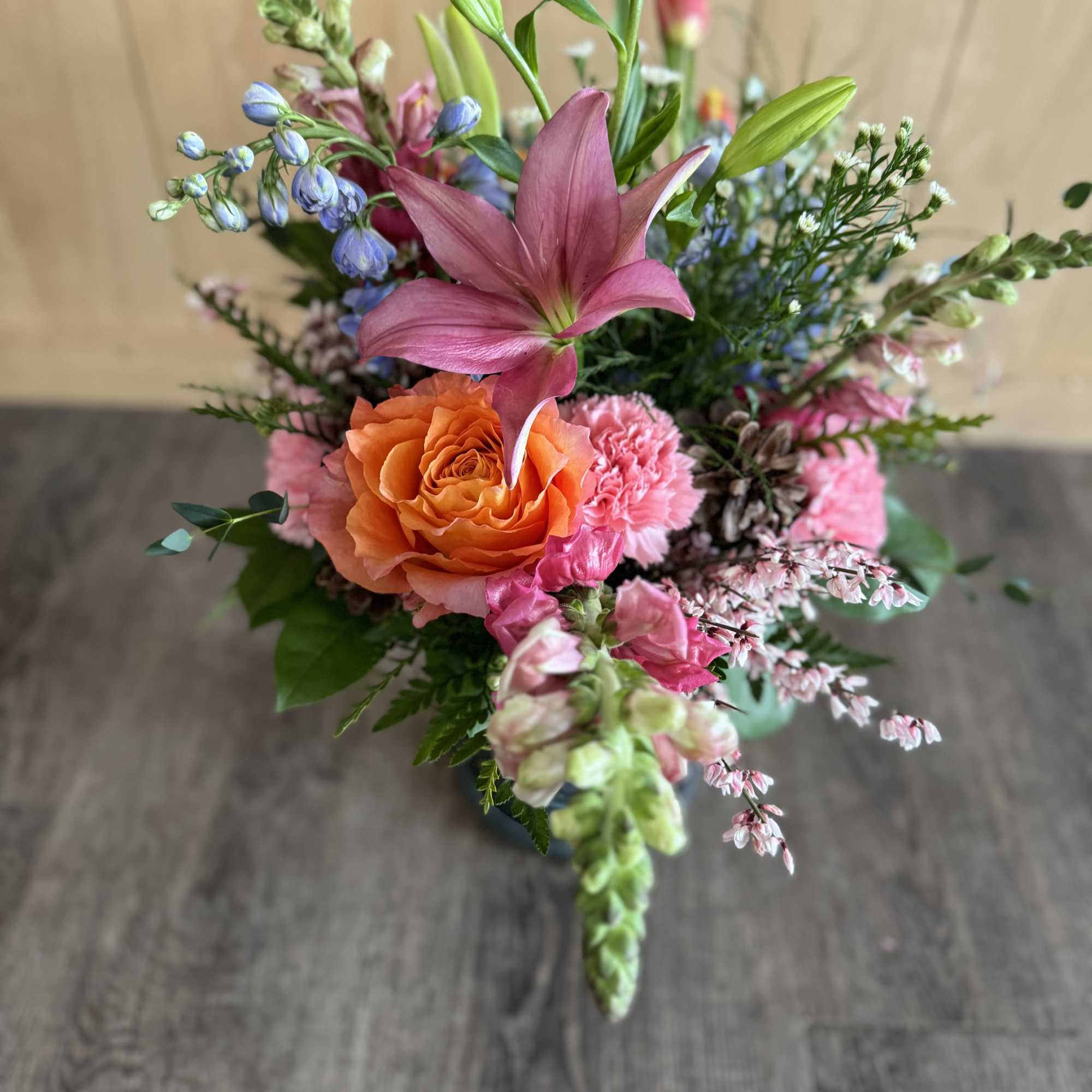 Mixed bouquet with pink lily, orange rose, and pastel flowers