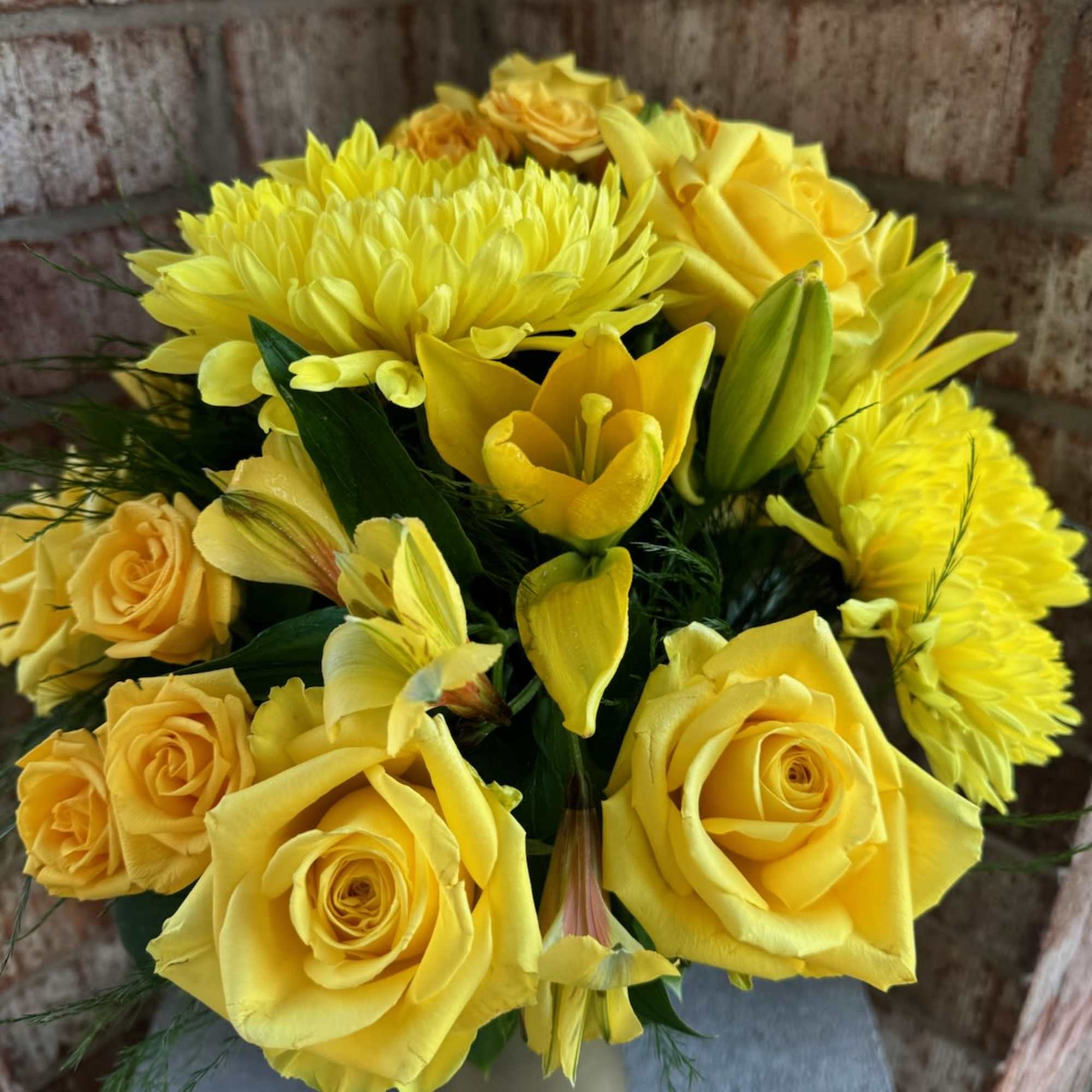 Yellow roses and chrysanthemums in a small vase