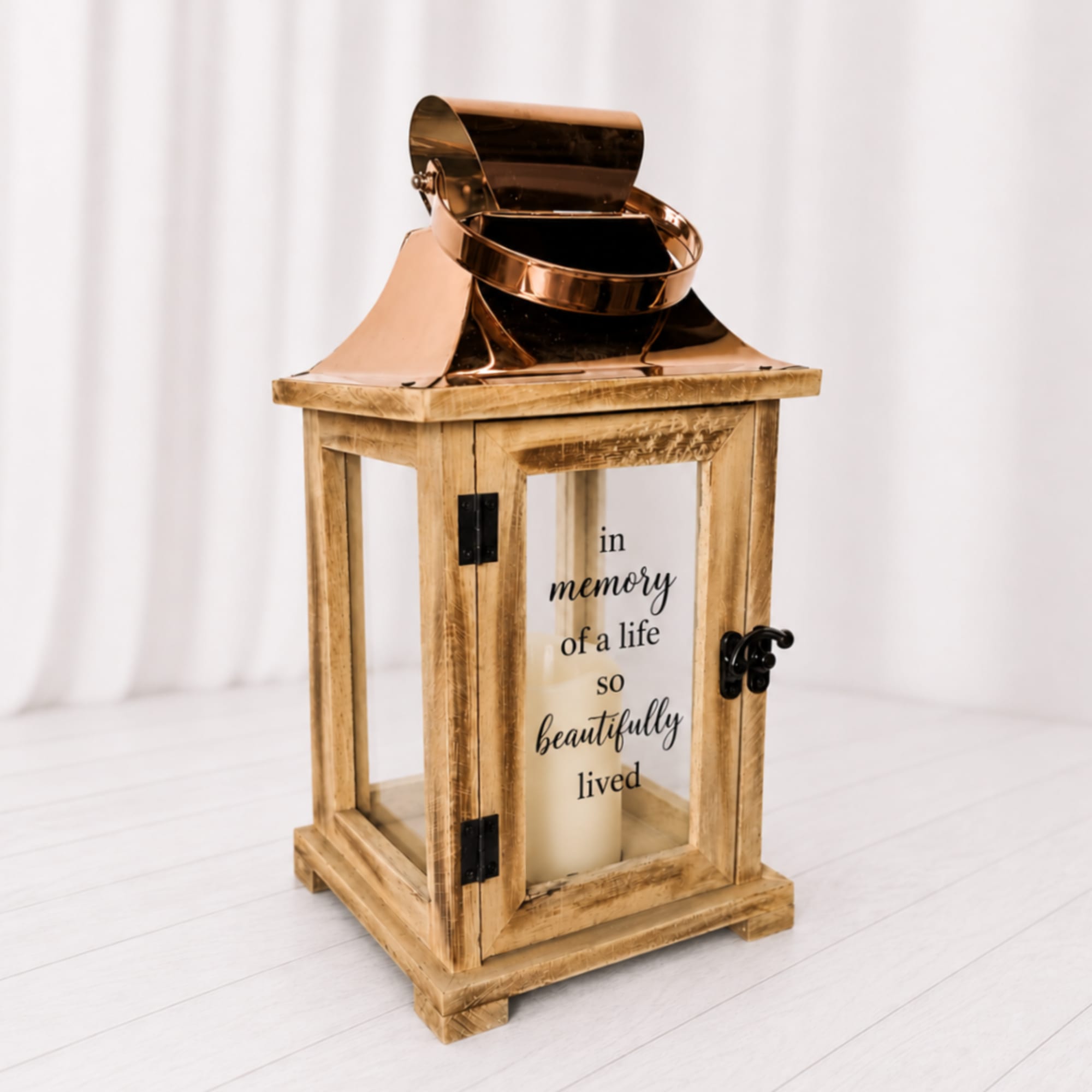 A cream candle in a rustic wooden lantern with copper top and