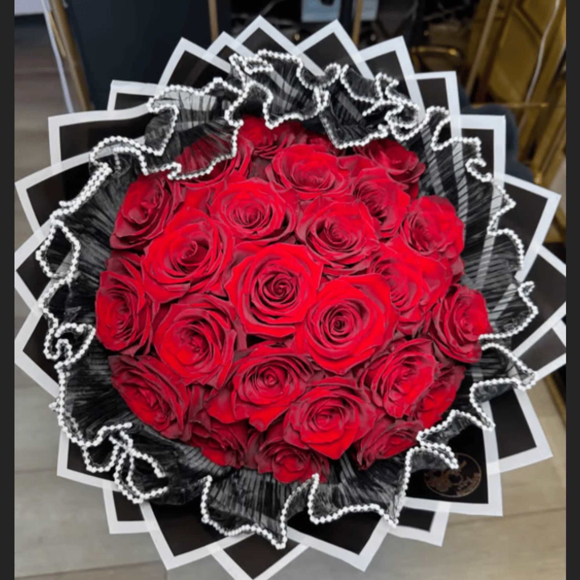 Bouquet of red roses wrapped in black and white paper