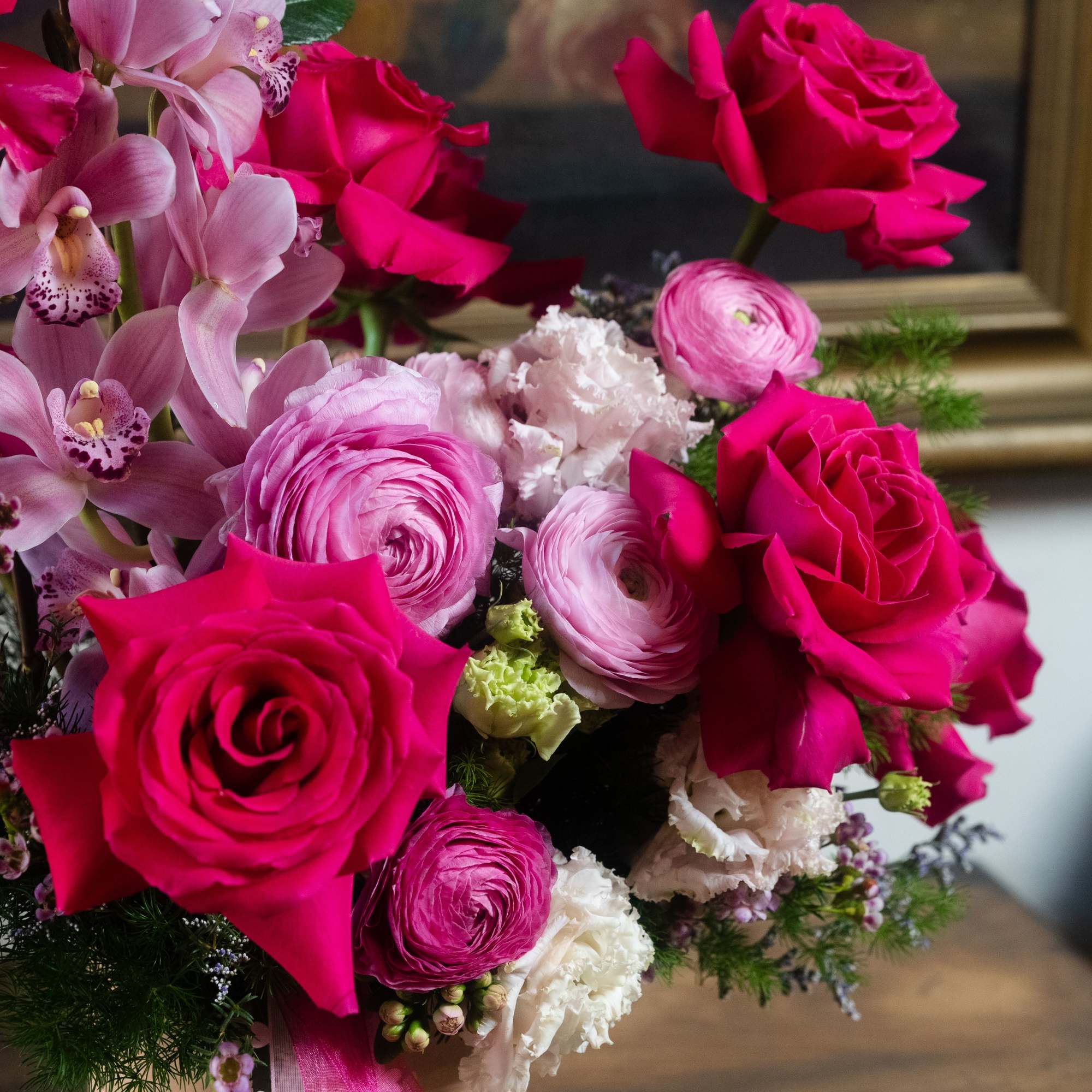 Pink and hot pink bouquet in a cream vase