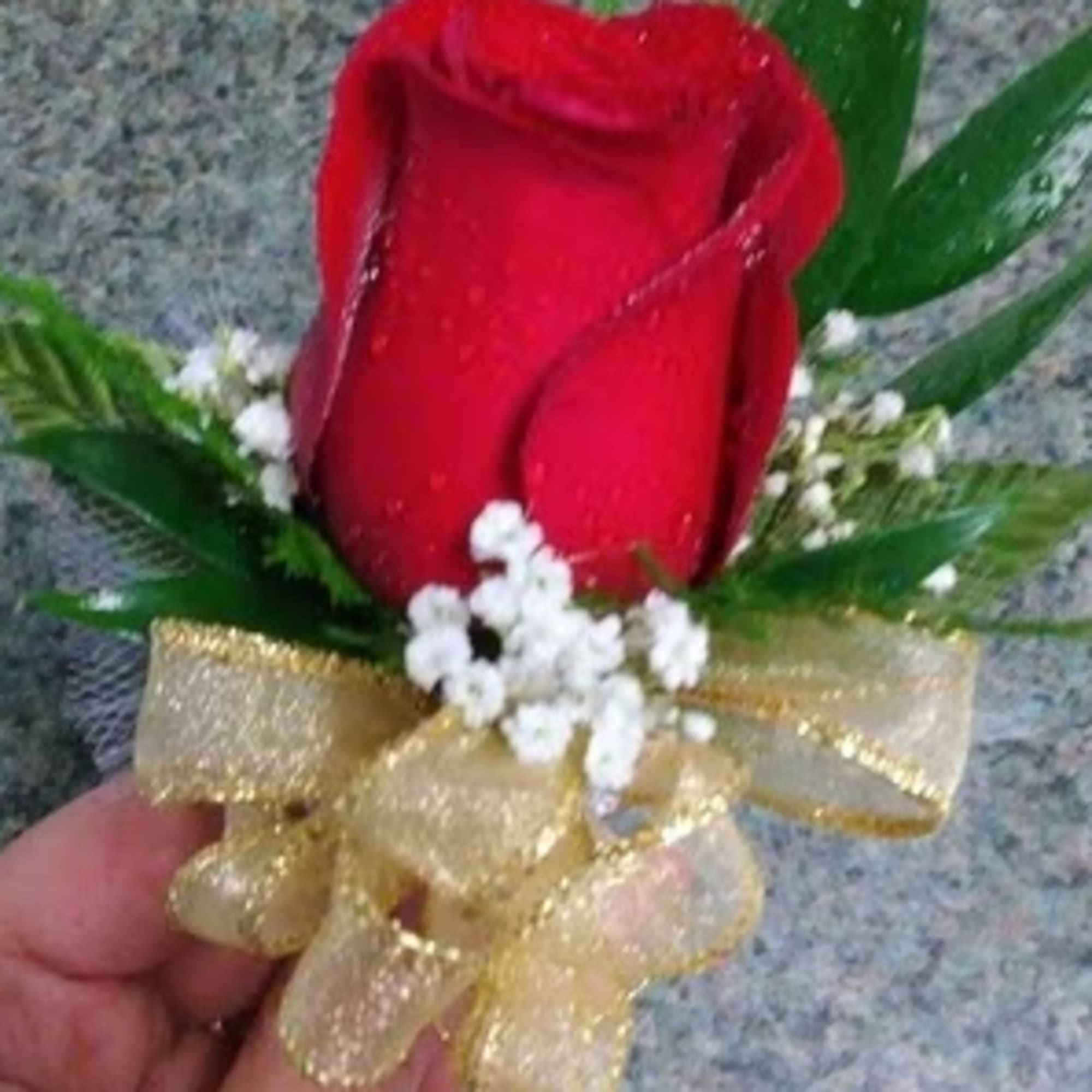 Red rose boutonniere with baby's breath and gold ribbon