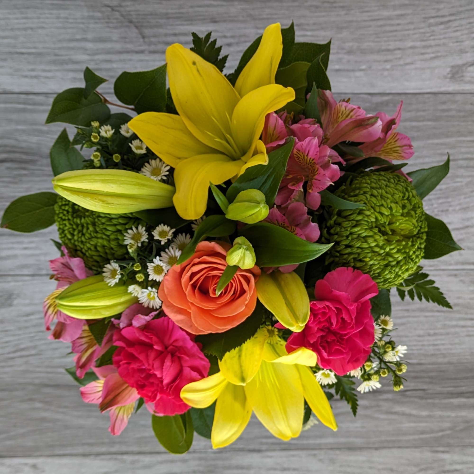 Bouquet with yellow lilies, pink flowers, and an orange rose