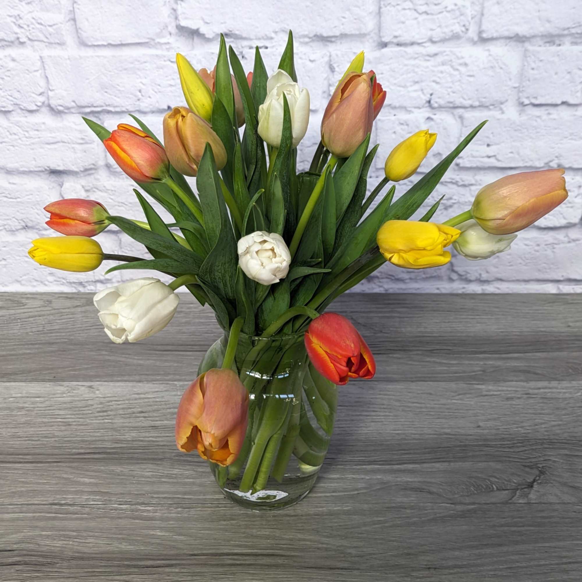 Bouquet of multicolored tulips in a clear glass vase