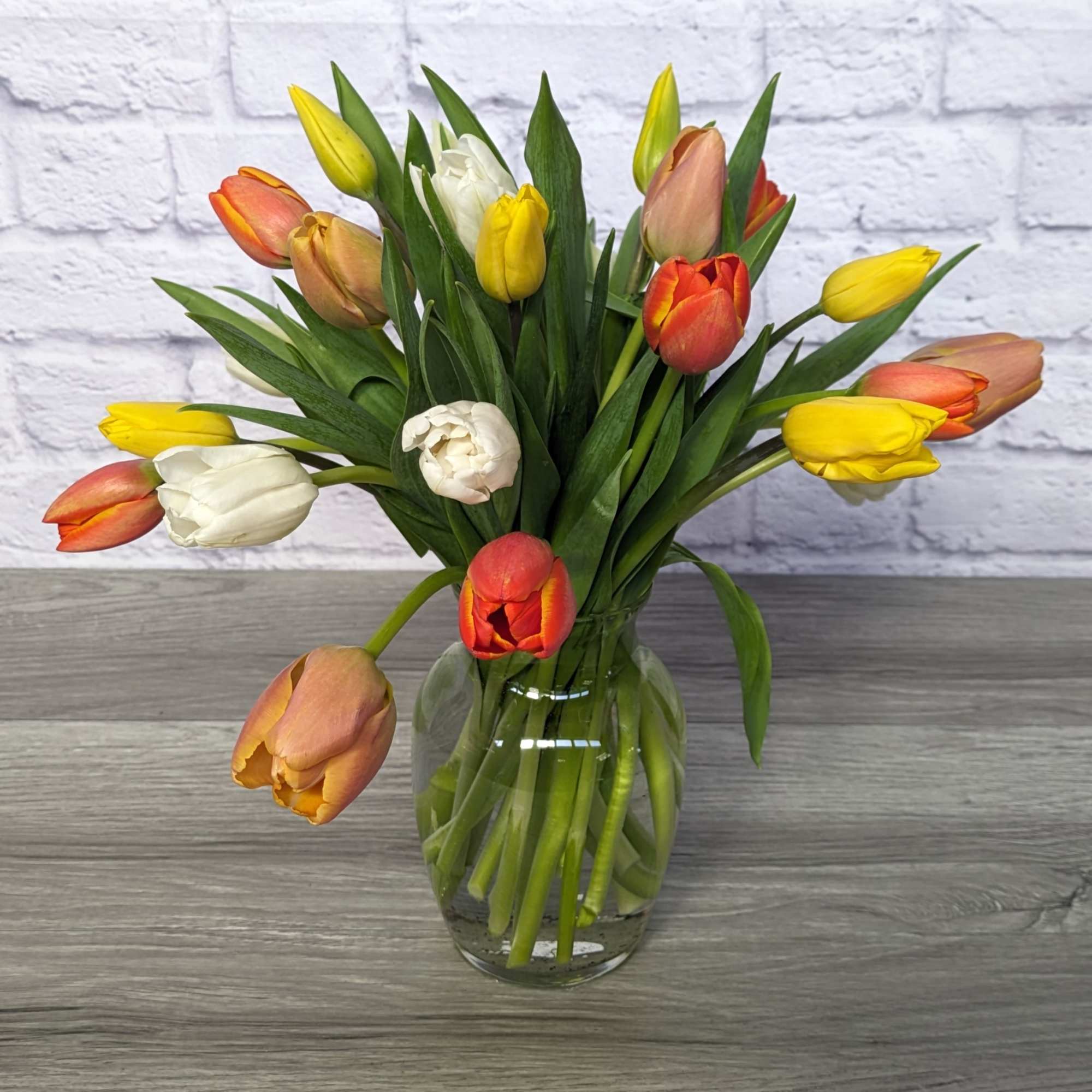 Bouquet of multicolored tulips in a clear glass vase