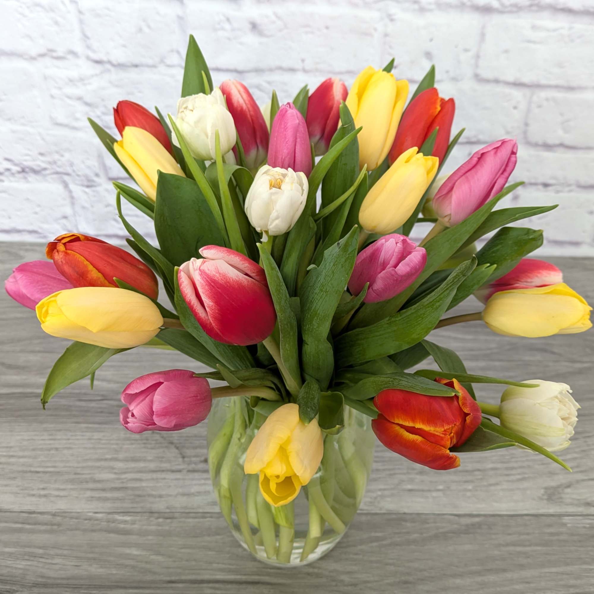Bouquet of multicolored tulips in a clear glass vase
