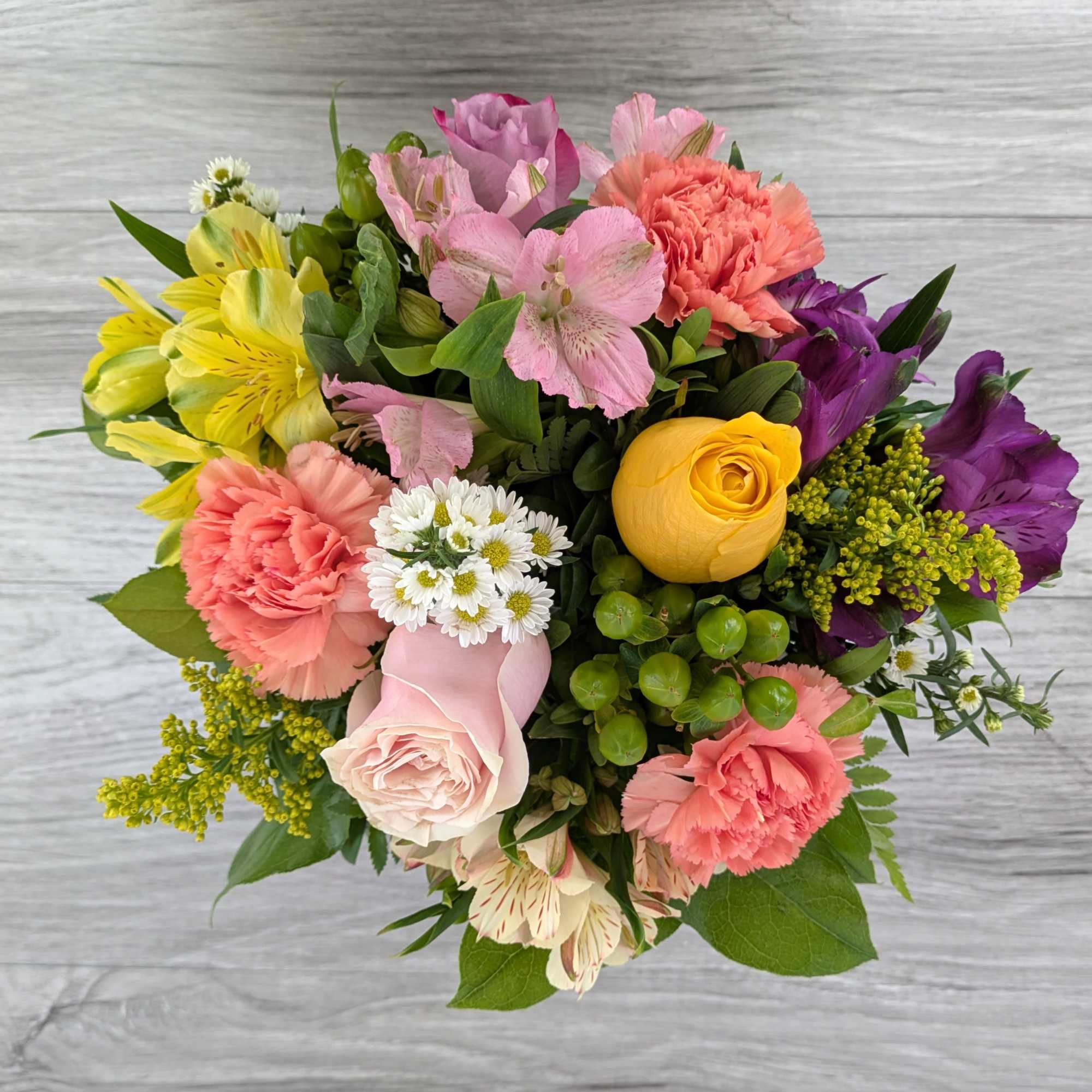 Mixed bouquet of pink, yellow, purple, and white flowers